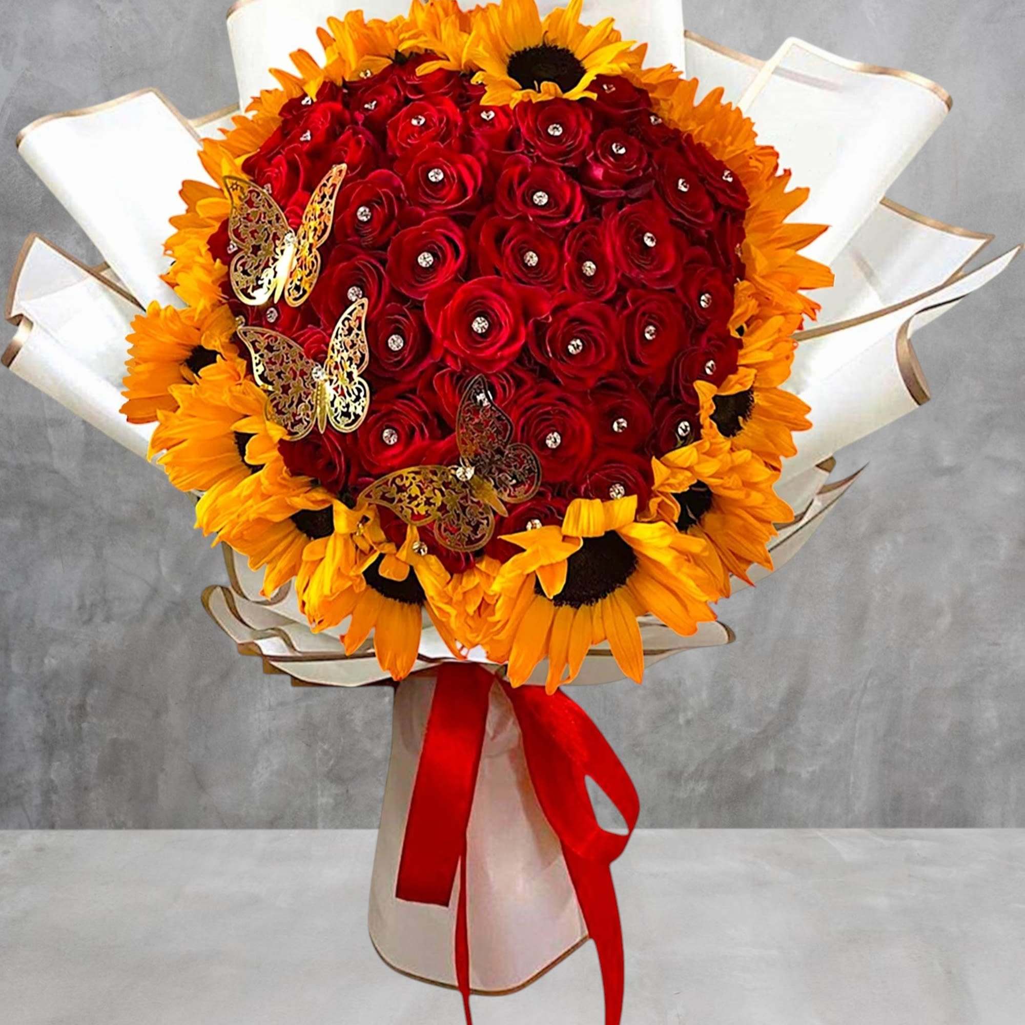 Bouquet of red roses and yellow sunflowers wrapped in white paper