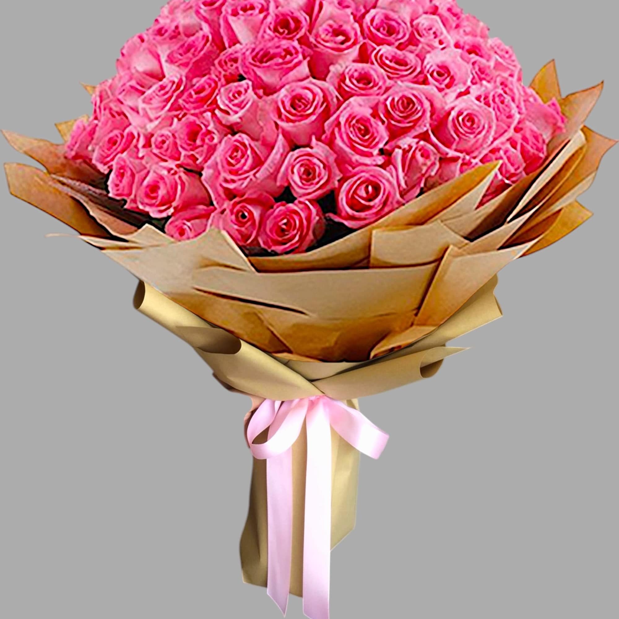 Large bouquet of bright pink roses wrapped in gold paper with a pink ribbon