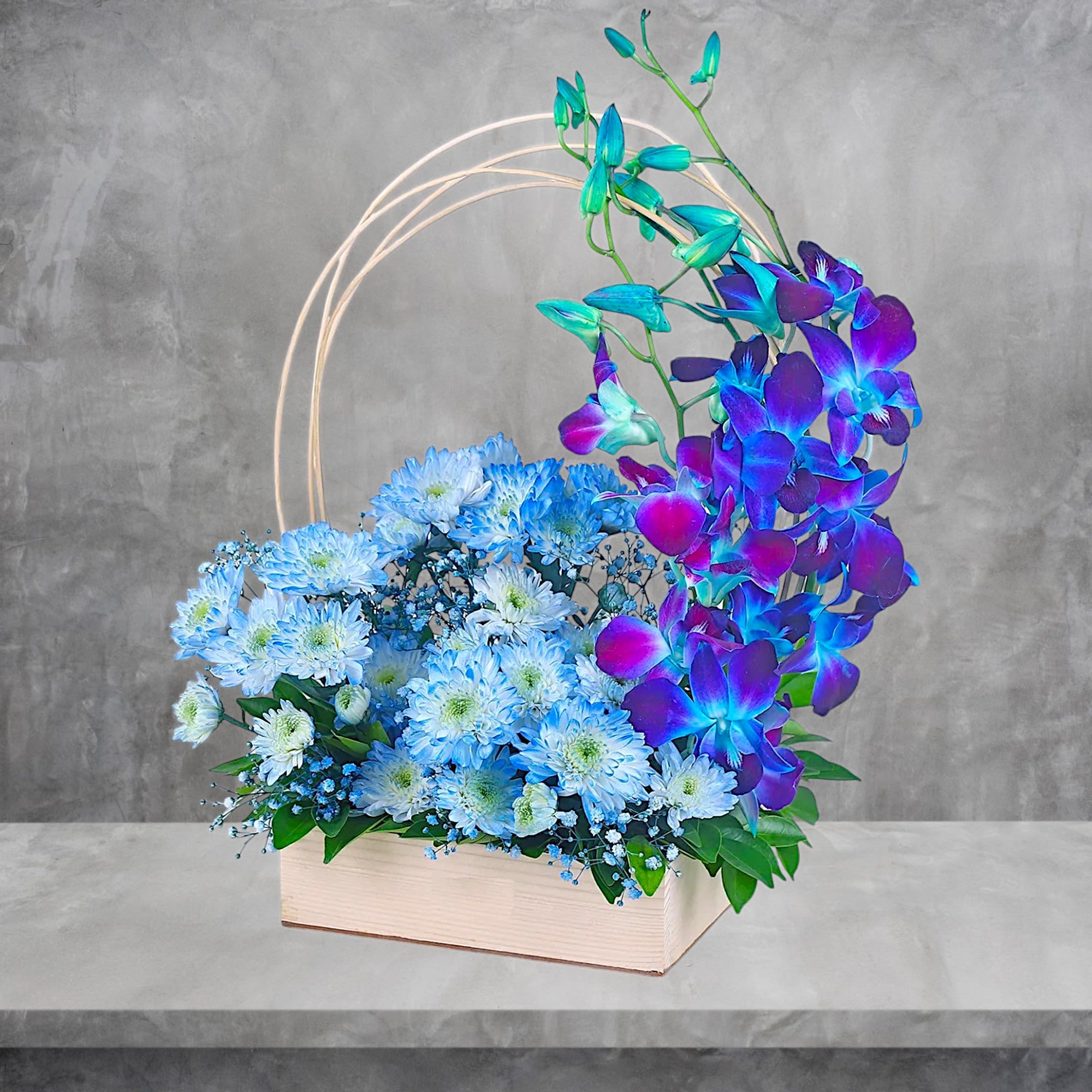 Blue chrysanthemums and purple orchids in a wooden box with a circular frame