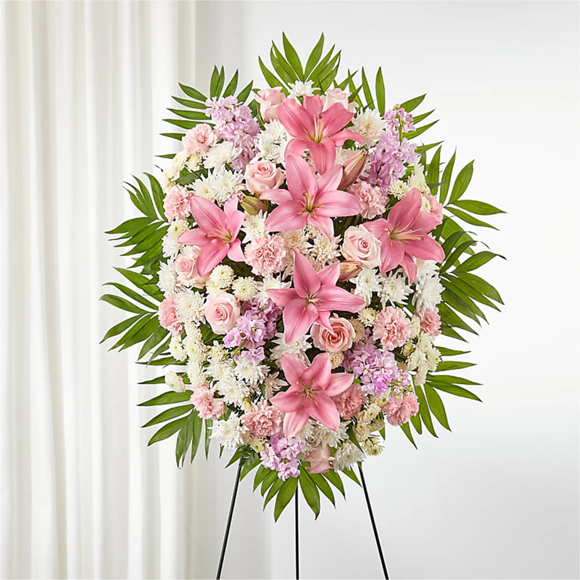 Pink lilies and roses in a standing floral spray on an easel