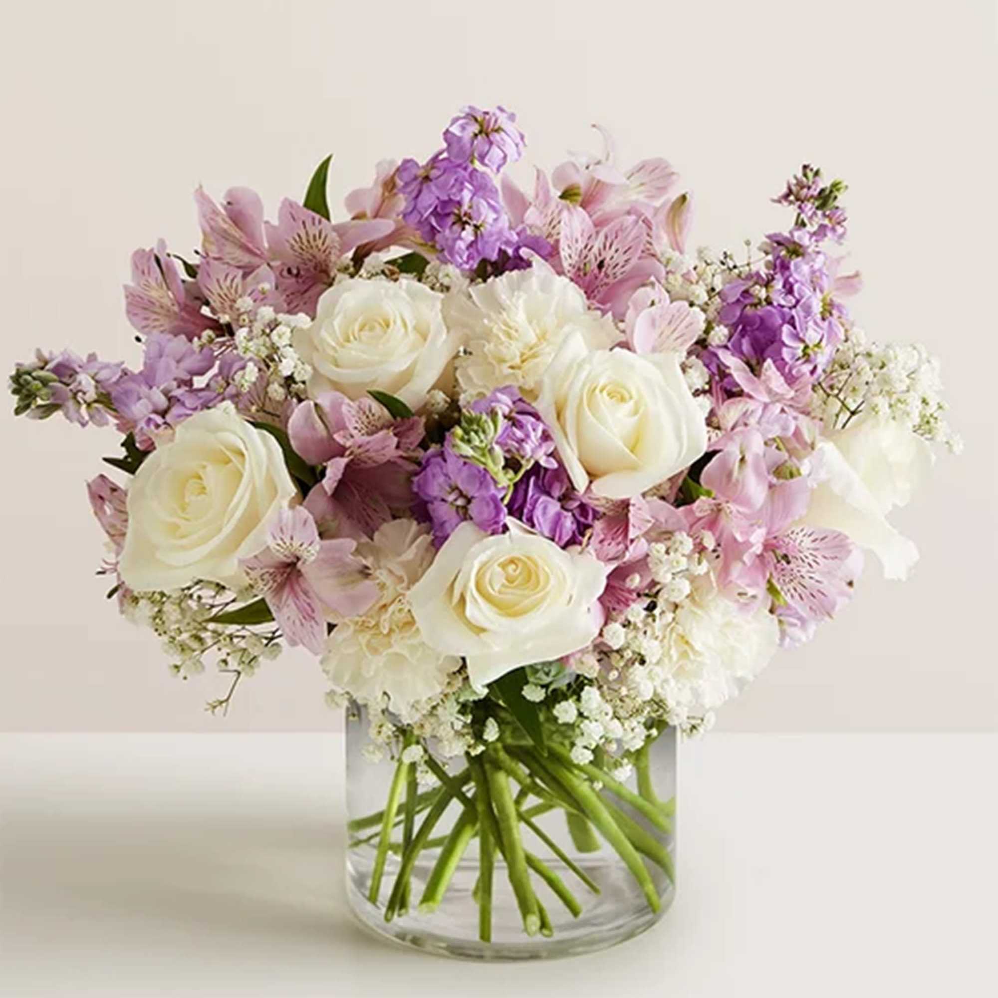 Pink and white bouquet of roses and lilies in a clear glass vase