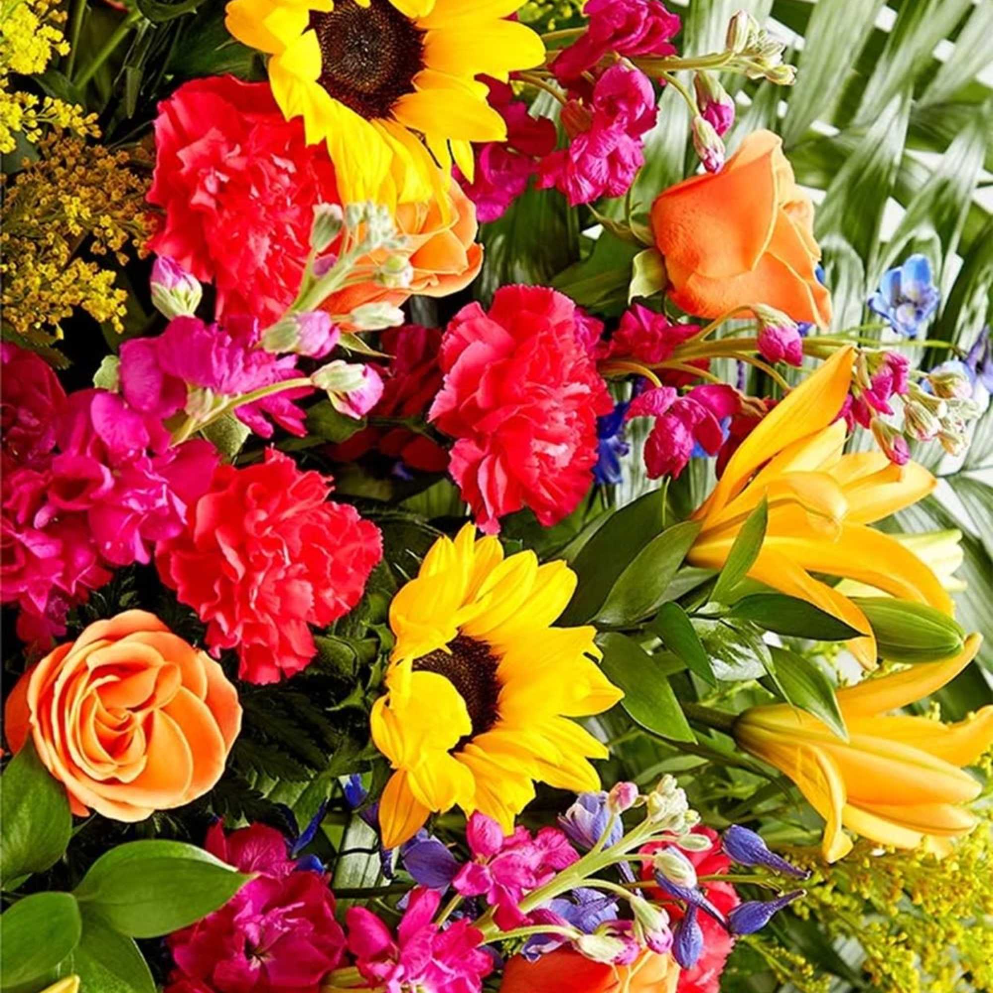 Bright mixed bouquet with sunflowers, roses, lilies, and carnations