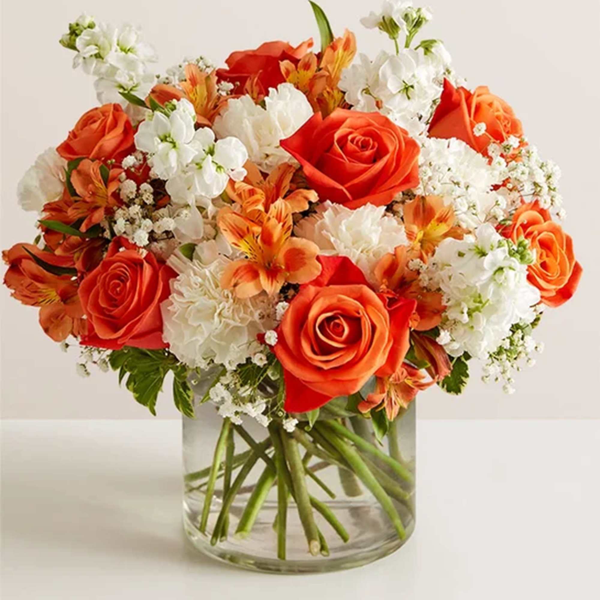 Orange and white mixed bouquet in a clear glass vase