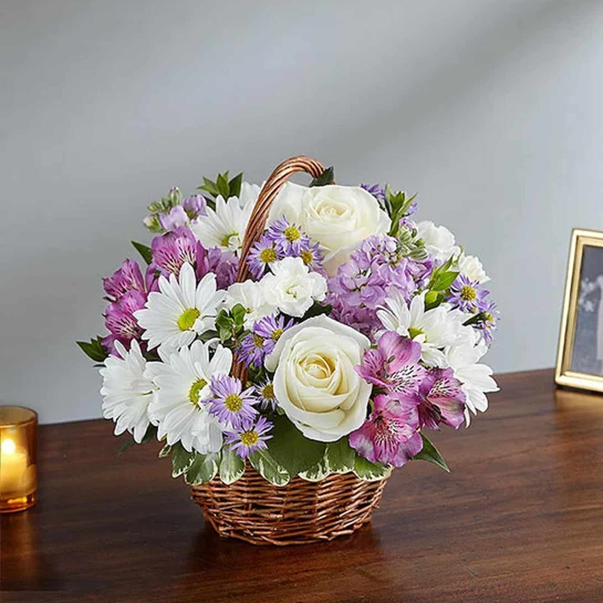 Basket arrangement of white roses, daisies, and purple flowers