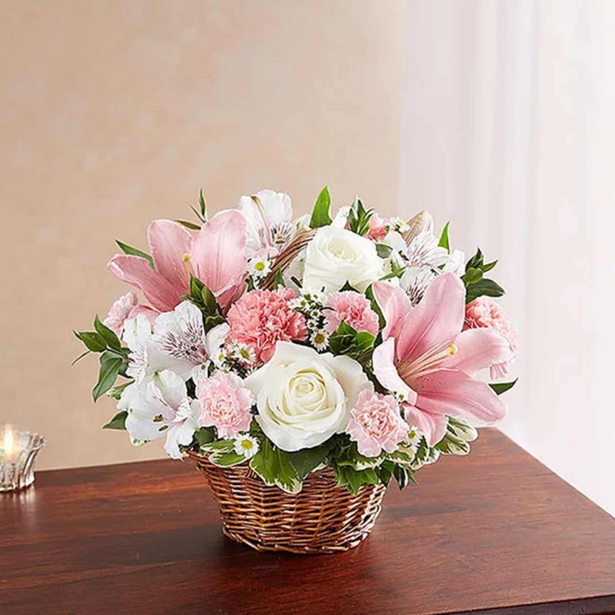 Pink and white flower arrangement in a wicker basket