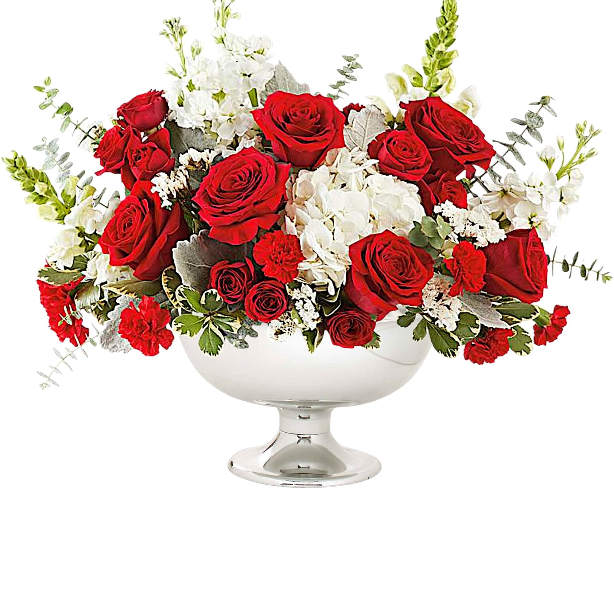 Red roses and white flowers arranged in a clear pedestal bowl