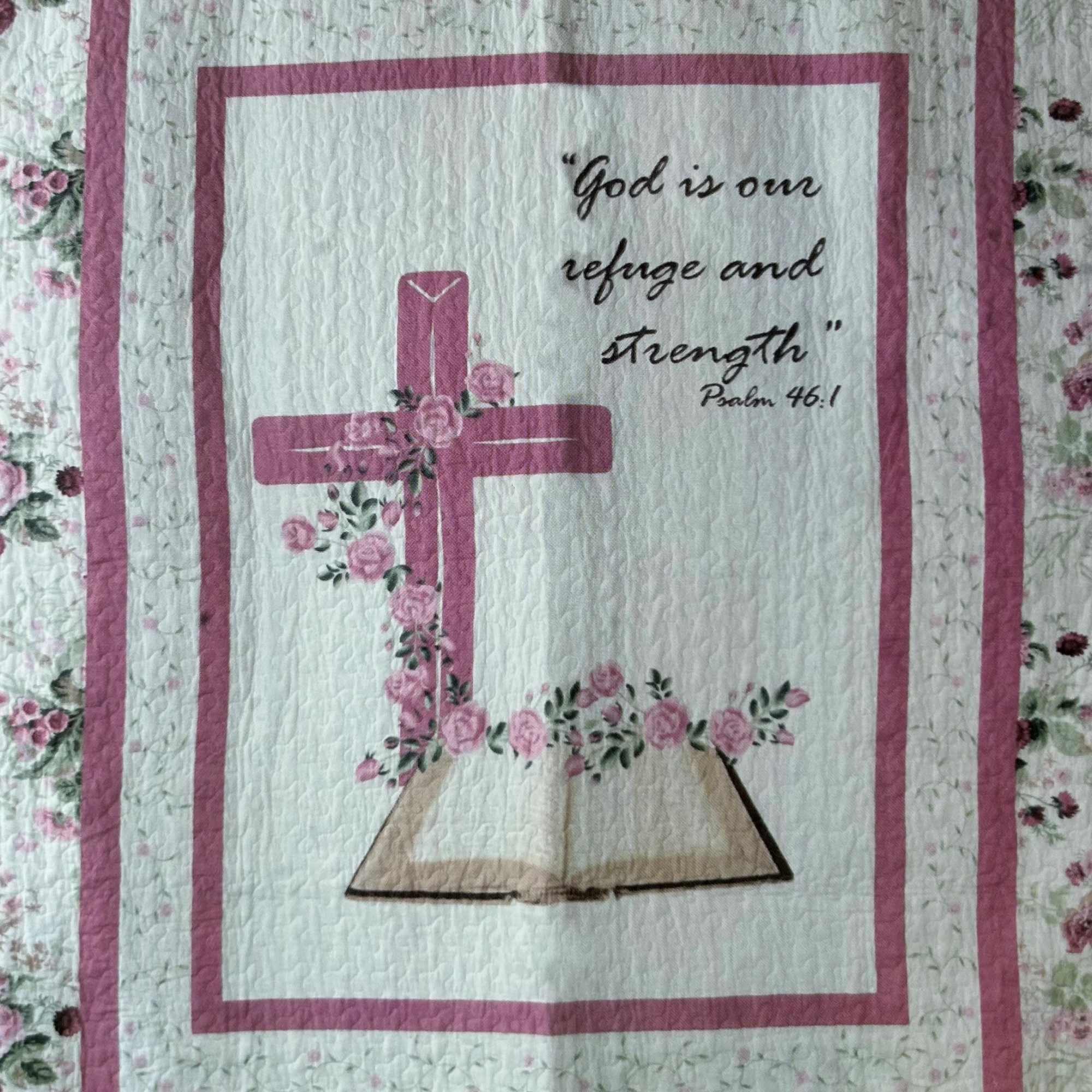 Quilt with a pink cross, flowers, and Bible verse text