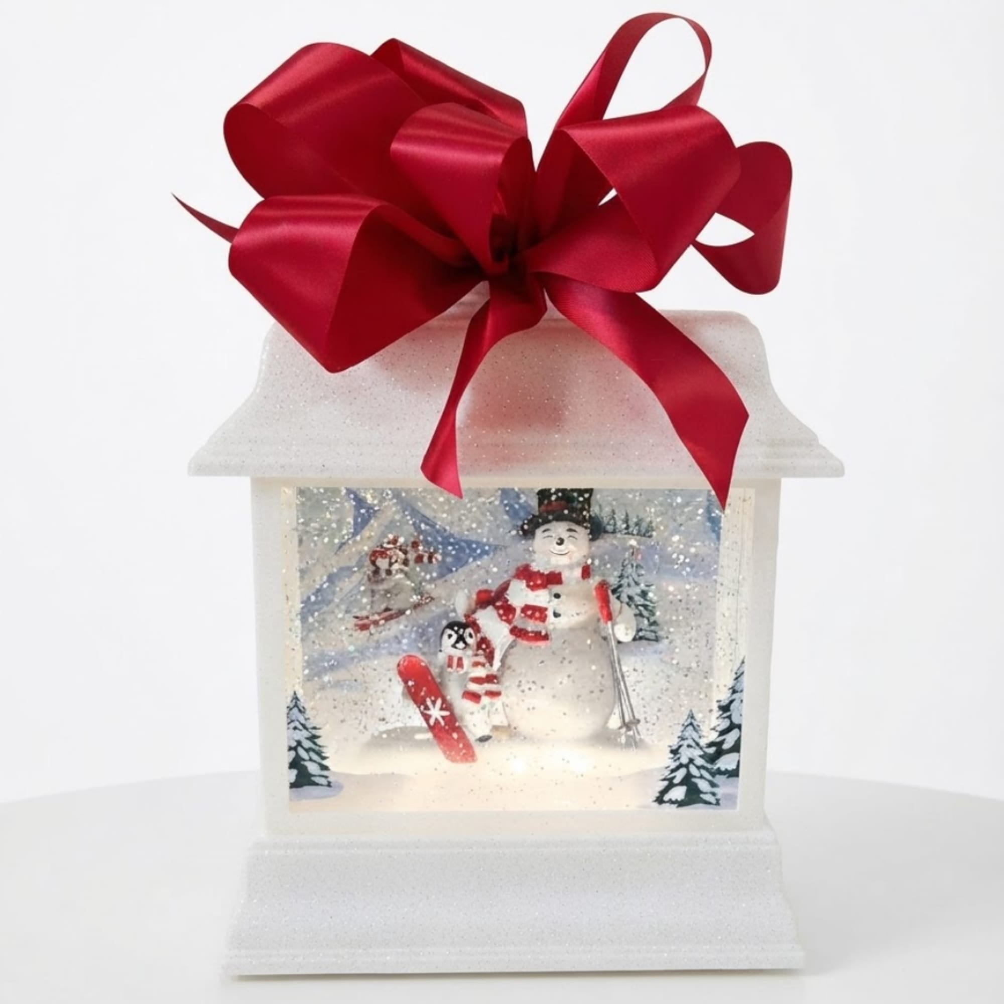 Snow globe lantern with a red bow and winter scene inside