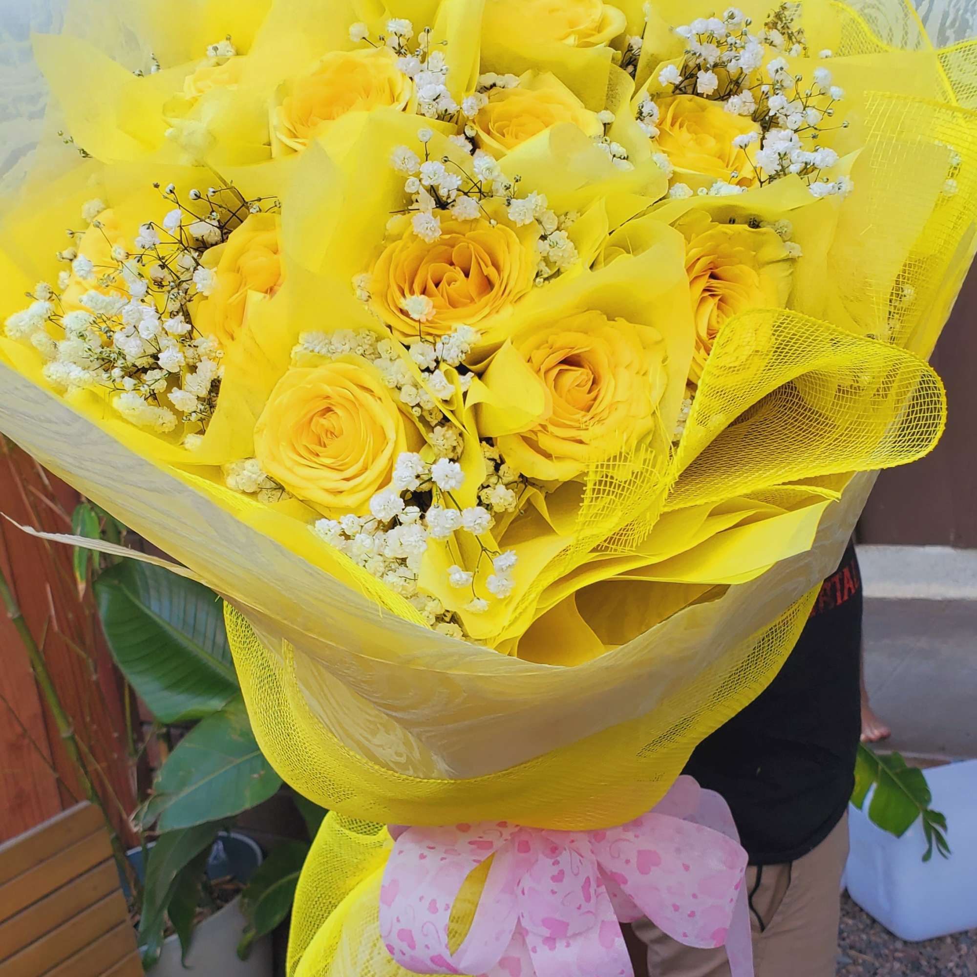 Bouquet of yellow roses with white baby's breath wrapped in yellow paper