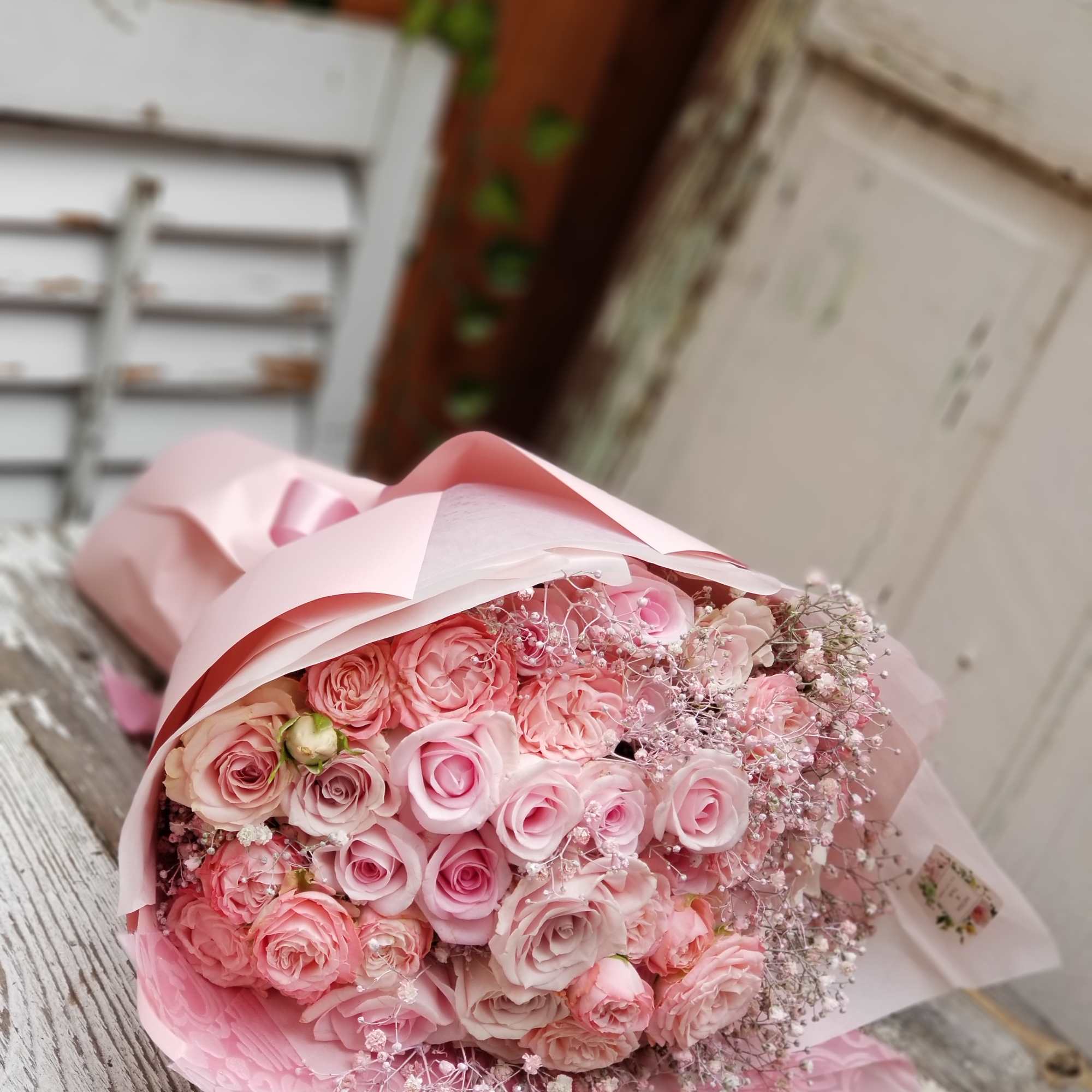 Pink rose bouquet wrapped in pale pink paper, photo 2 of 3