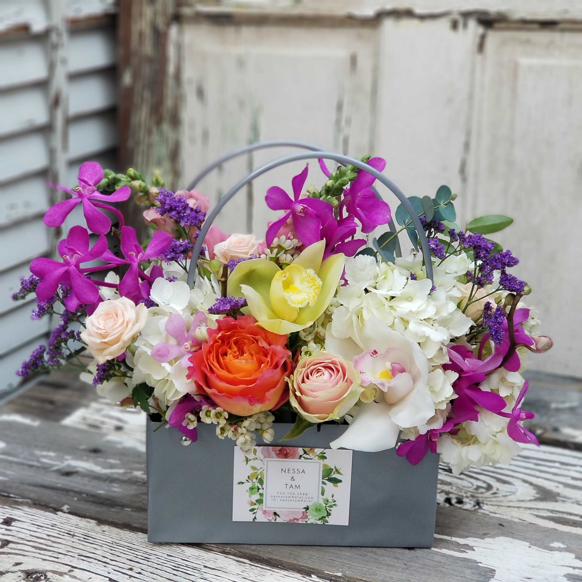 Mixed floral arrangement in a gray box with a handle