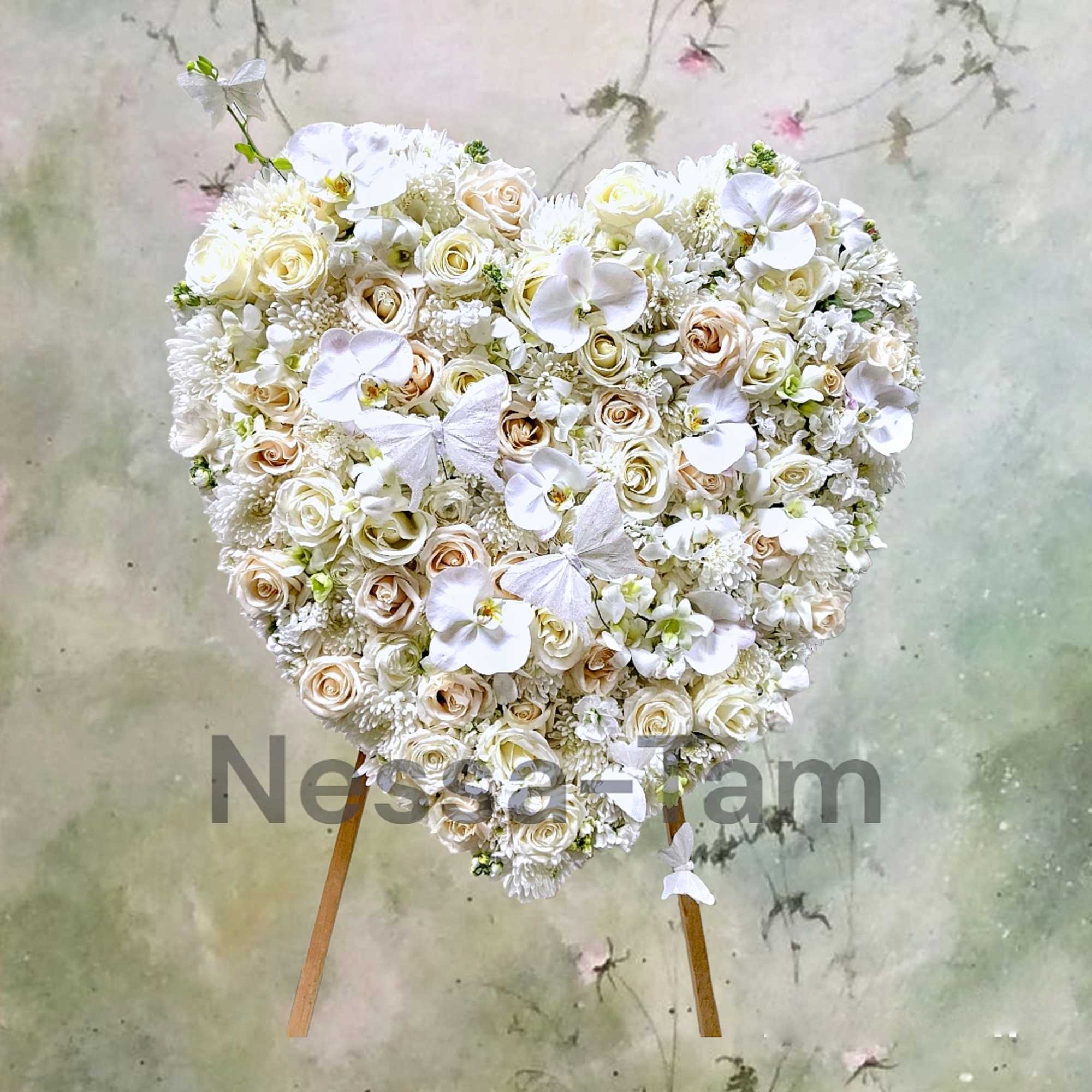 Heart-shaped white floral arrangement on a stand