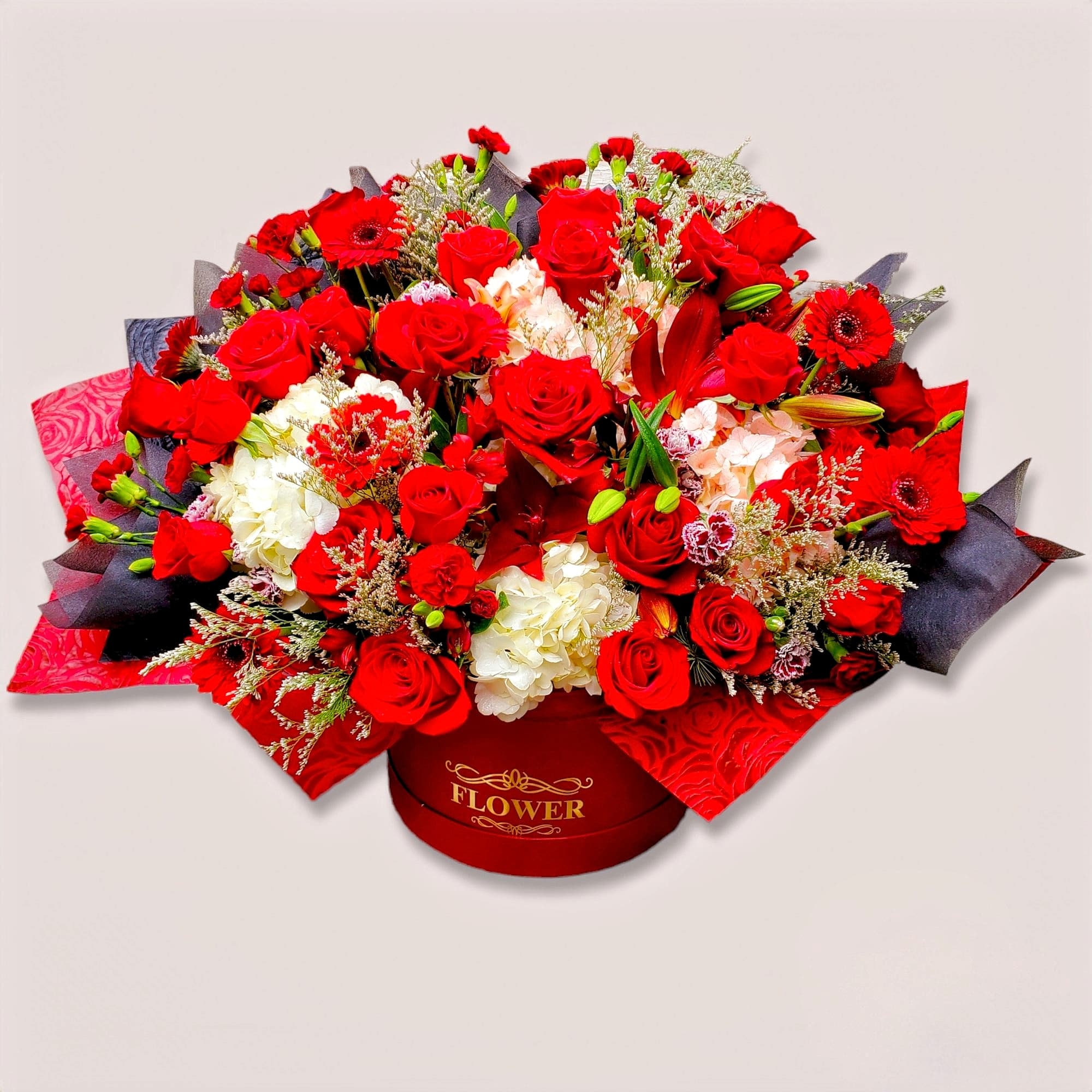 Red roses and white hydrangeas arranged in a round gift box