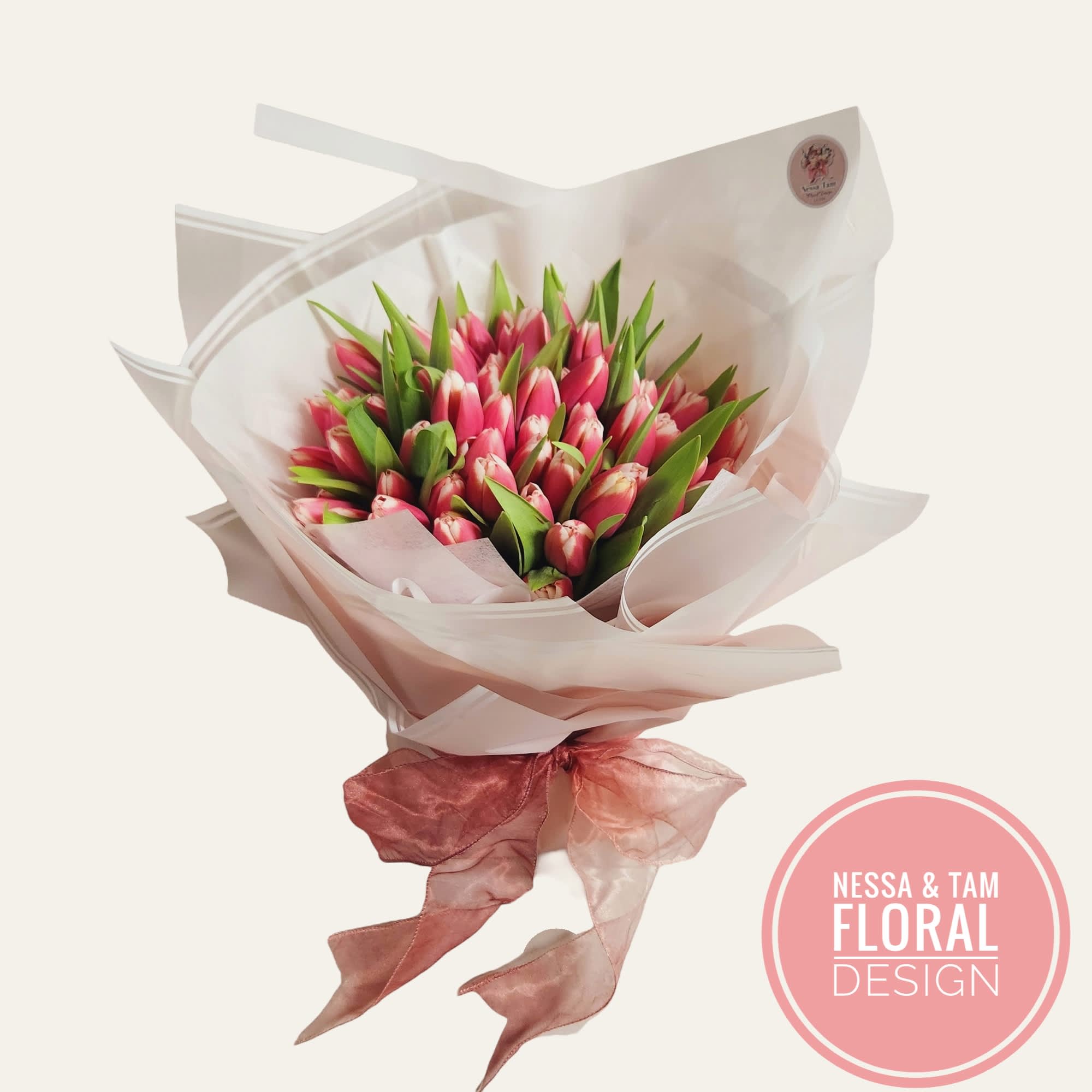 Bouquet of pink tulips wrapped in pale paper with a ribbon