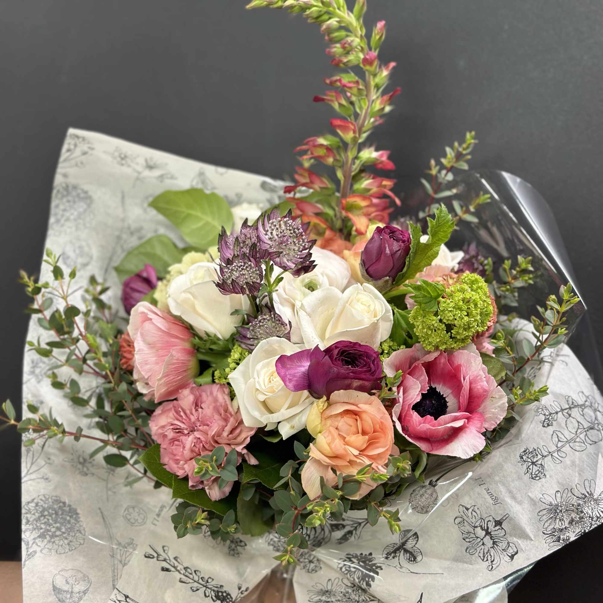 Designers Choice of Seasonal Flowers wrapped in specialty paper with coordinating ribbon