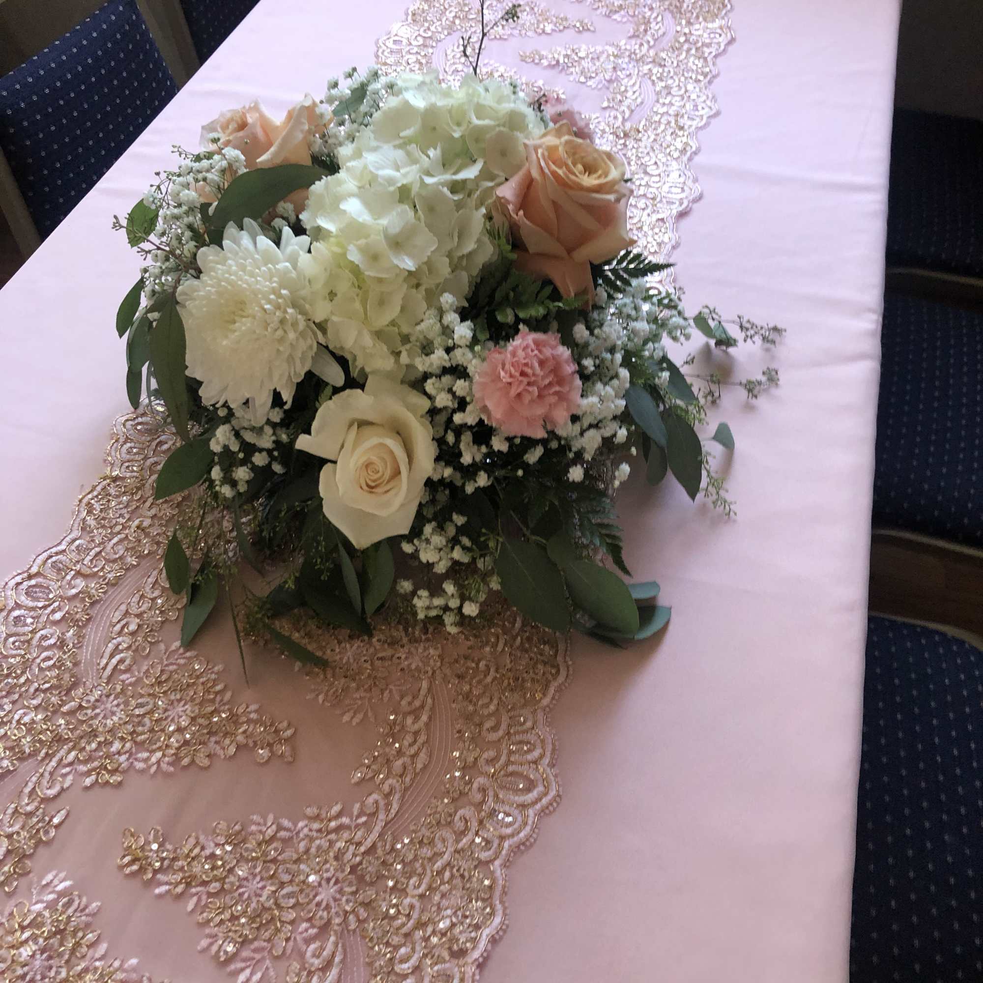 Pink and gold table runner with a pastel floral centerpiece