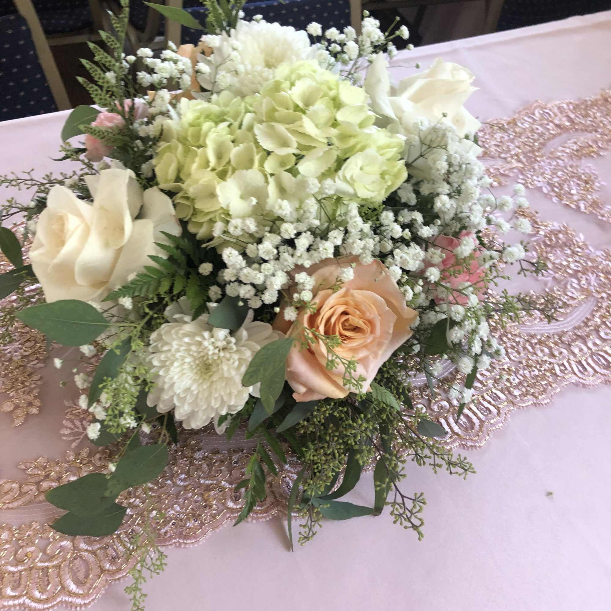 Pastel bouquet with cream roses, hydrangea, and white filler flowers