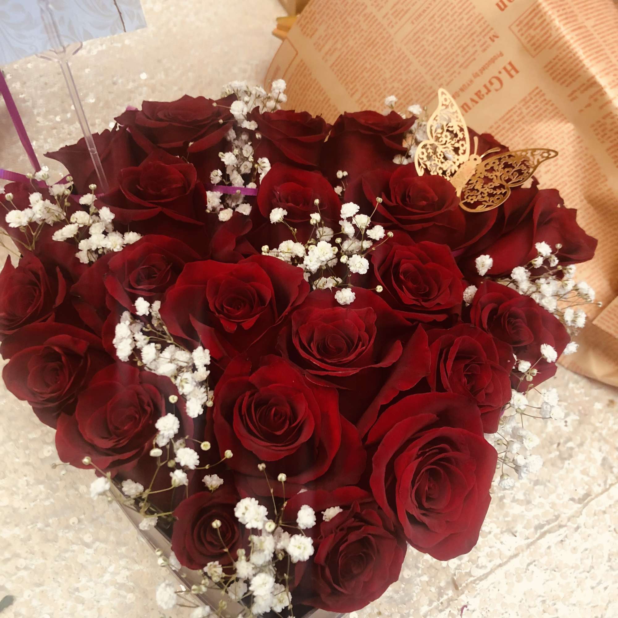 Bouquet of red roses with white baby's breath in wrapped packaging