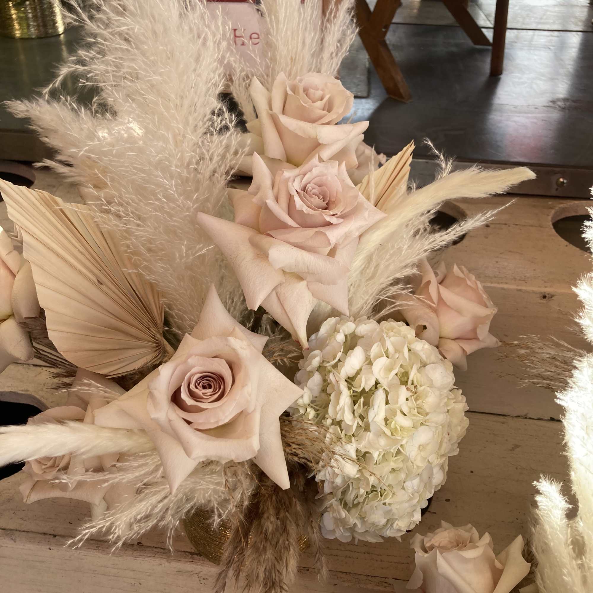 Blush roses and white hydrangea with tall pampas grass in a low arrangement