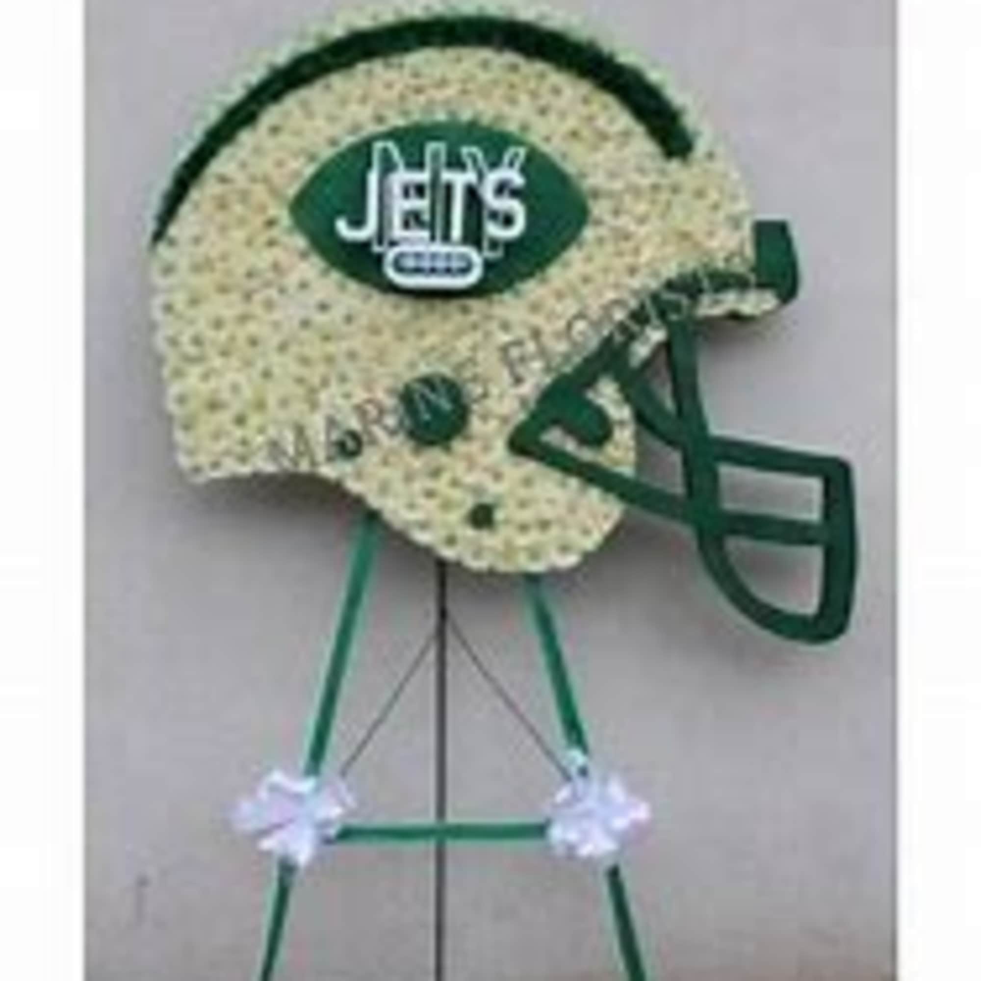 Football-shaped floral tribute on a stand with a Jets logo