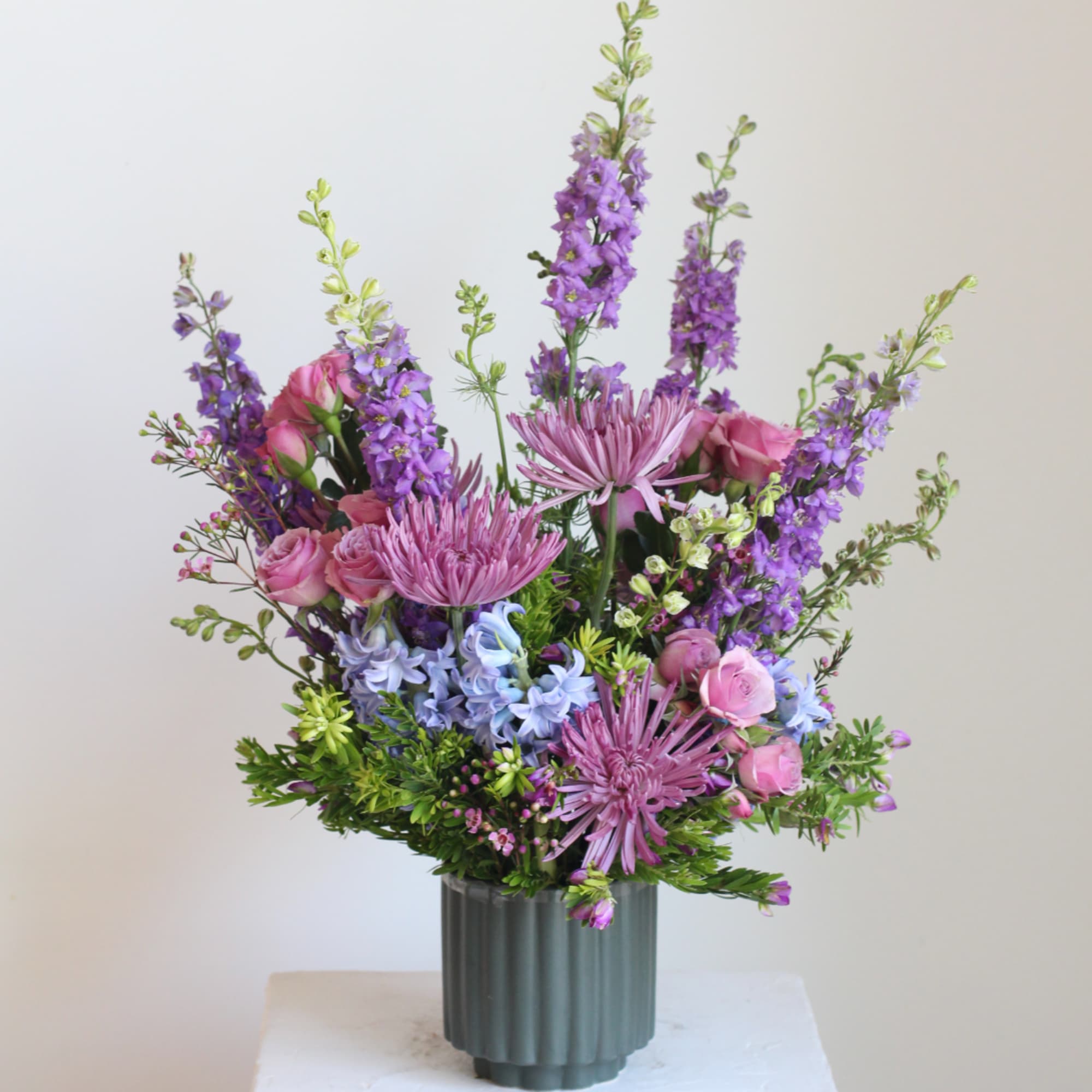 Pink and purple mixed bouquet in a ribbed gray vase