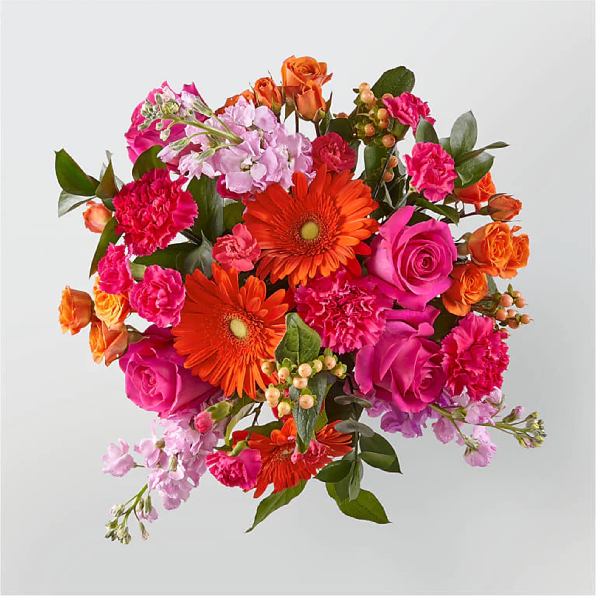 Bright bouquet of orange gerbera daisies, hot pink roses, and carnations with light pink stock