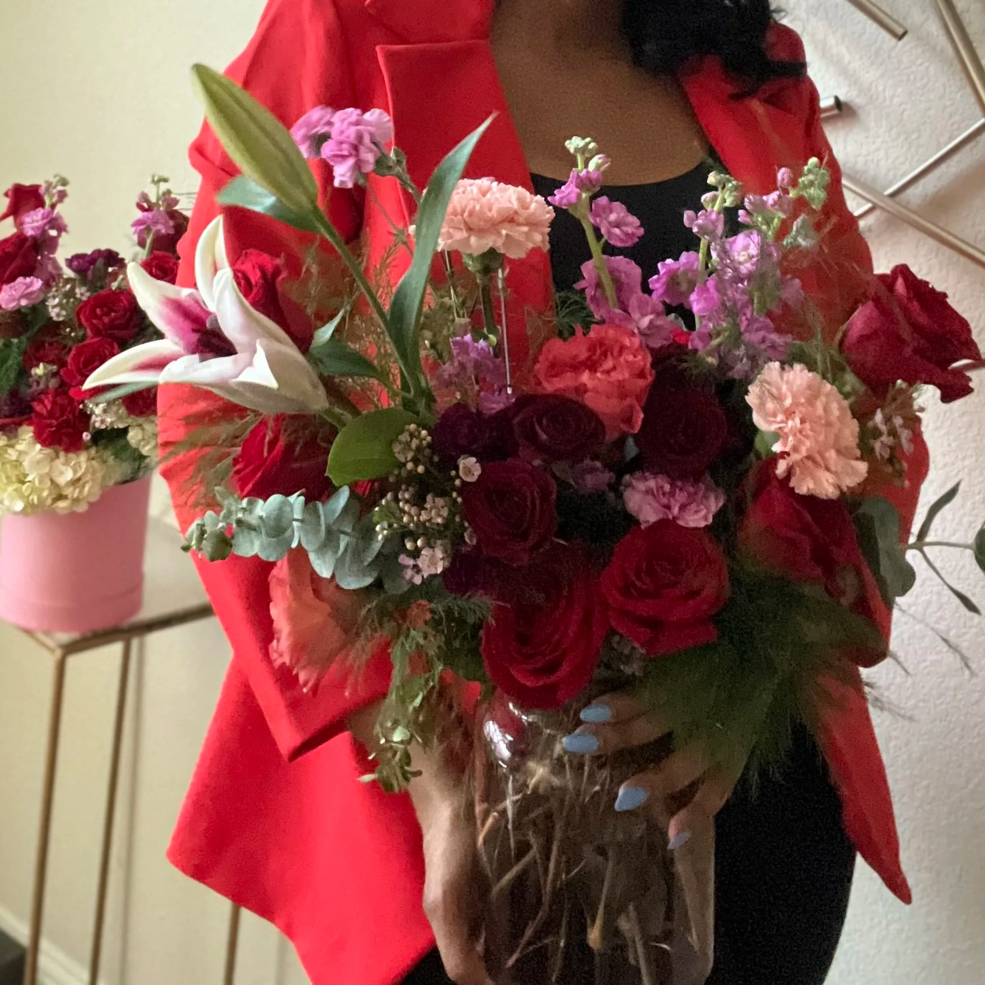 Large bouquet of red roses, lilies, and pink flowers in a clear vase