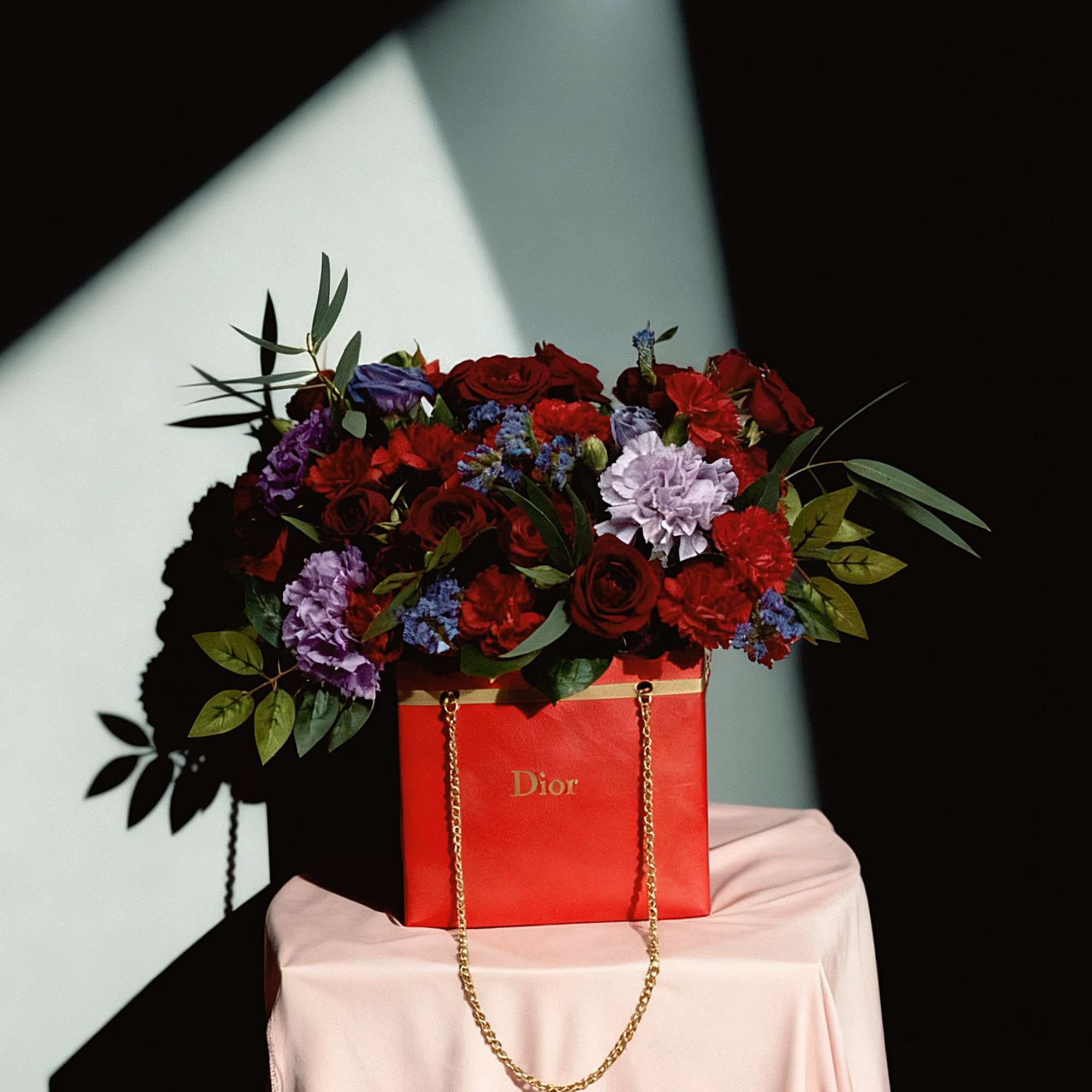 Red and purple flower arrangement in a red Dior gift bag, photo 2 of 3