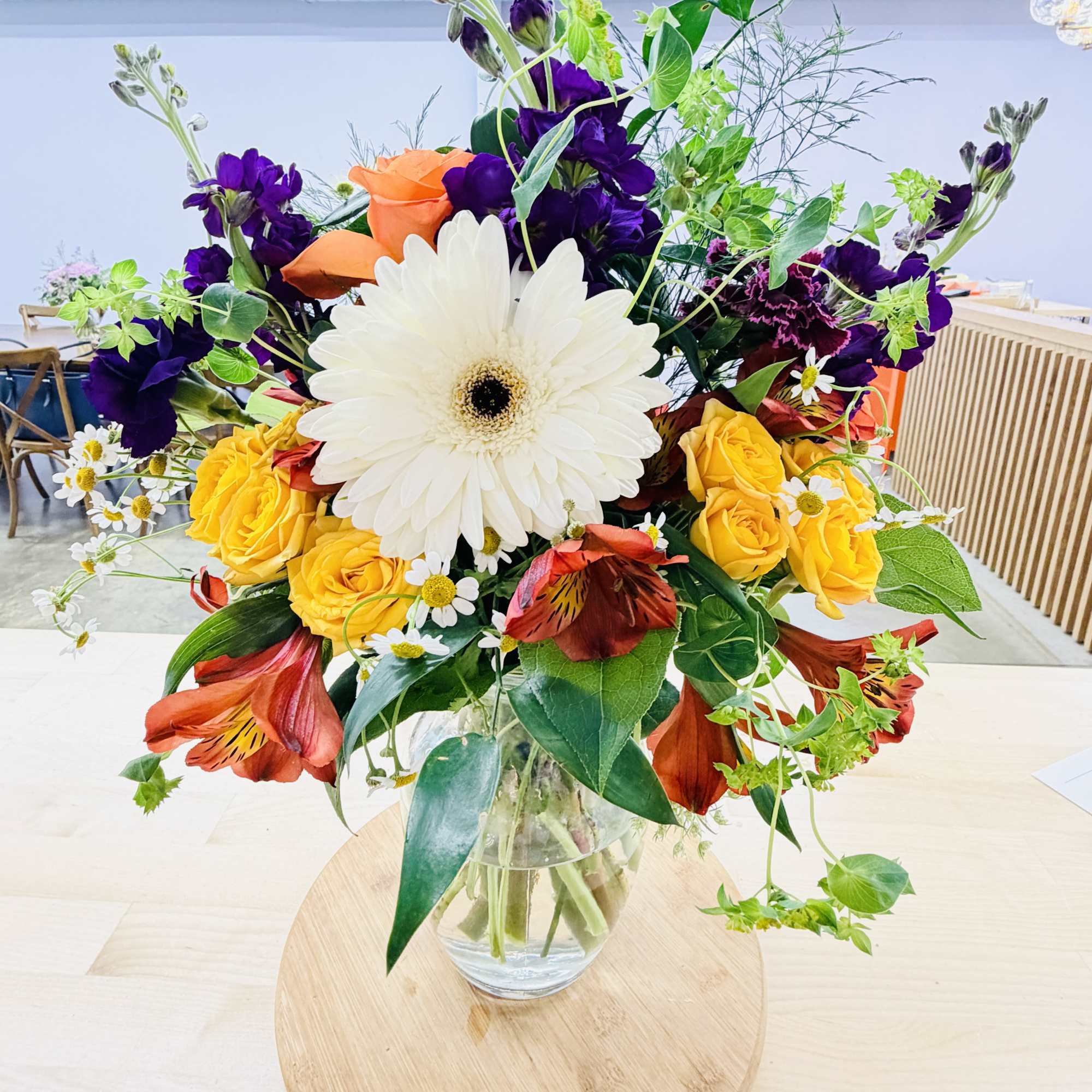 A bright 'star of the show' gerbera daisy (color may vary) crowns