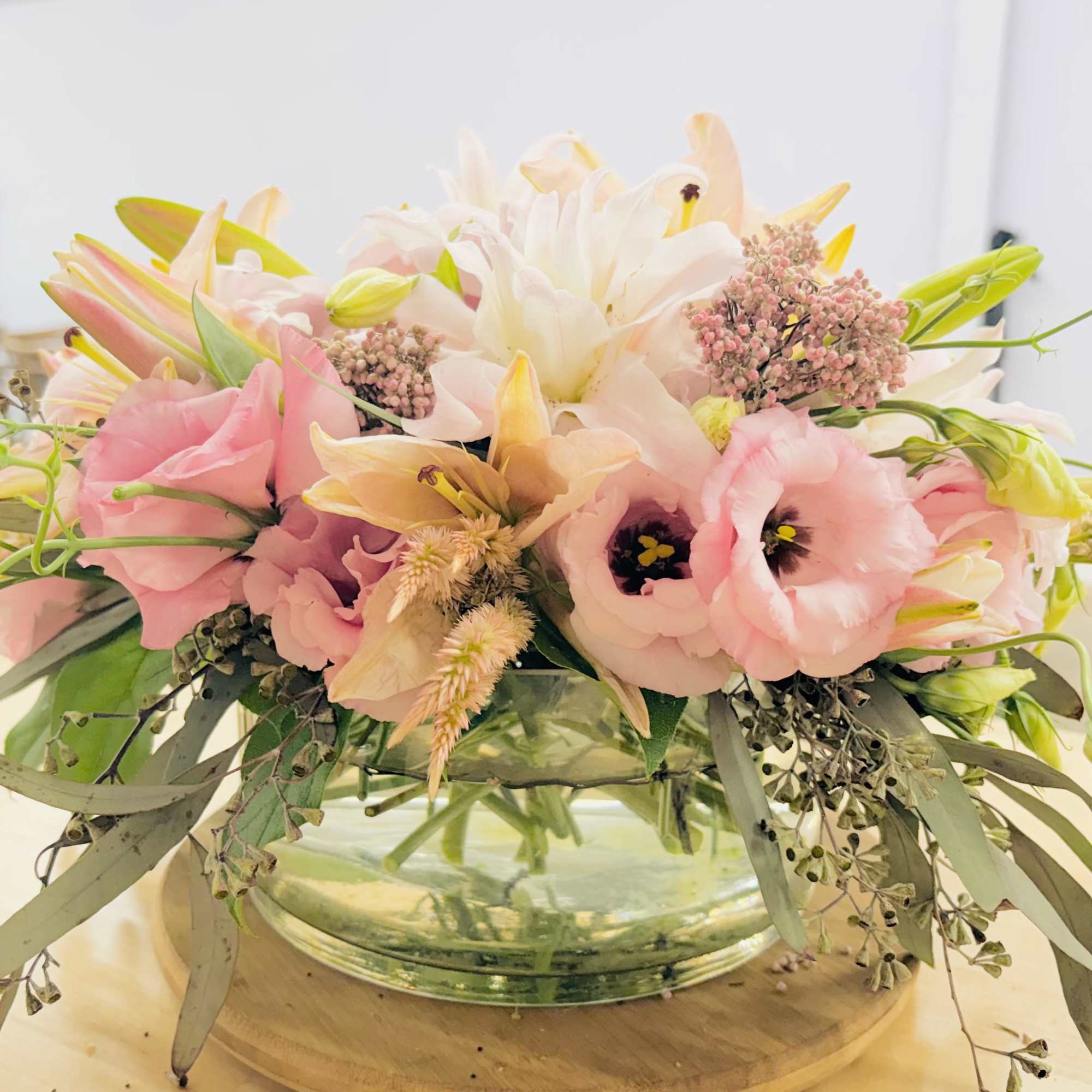 Low pastel bouquet in a clear glass bowl vase