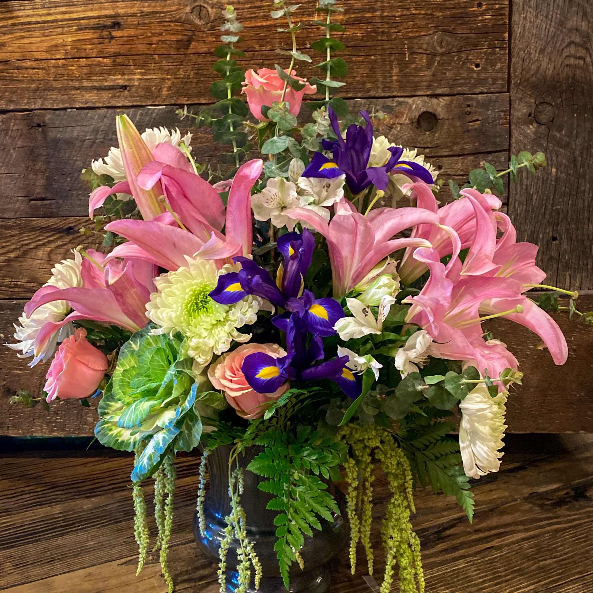 Pink lilies and purple irises in a glass vase