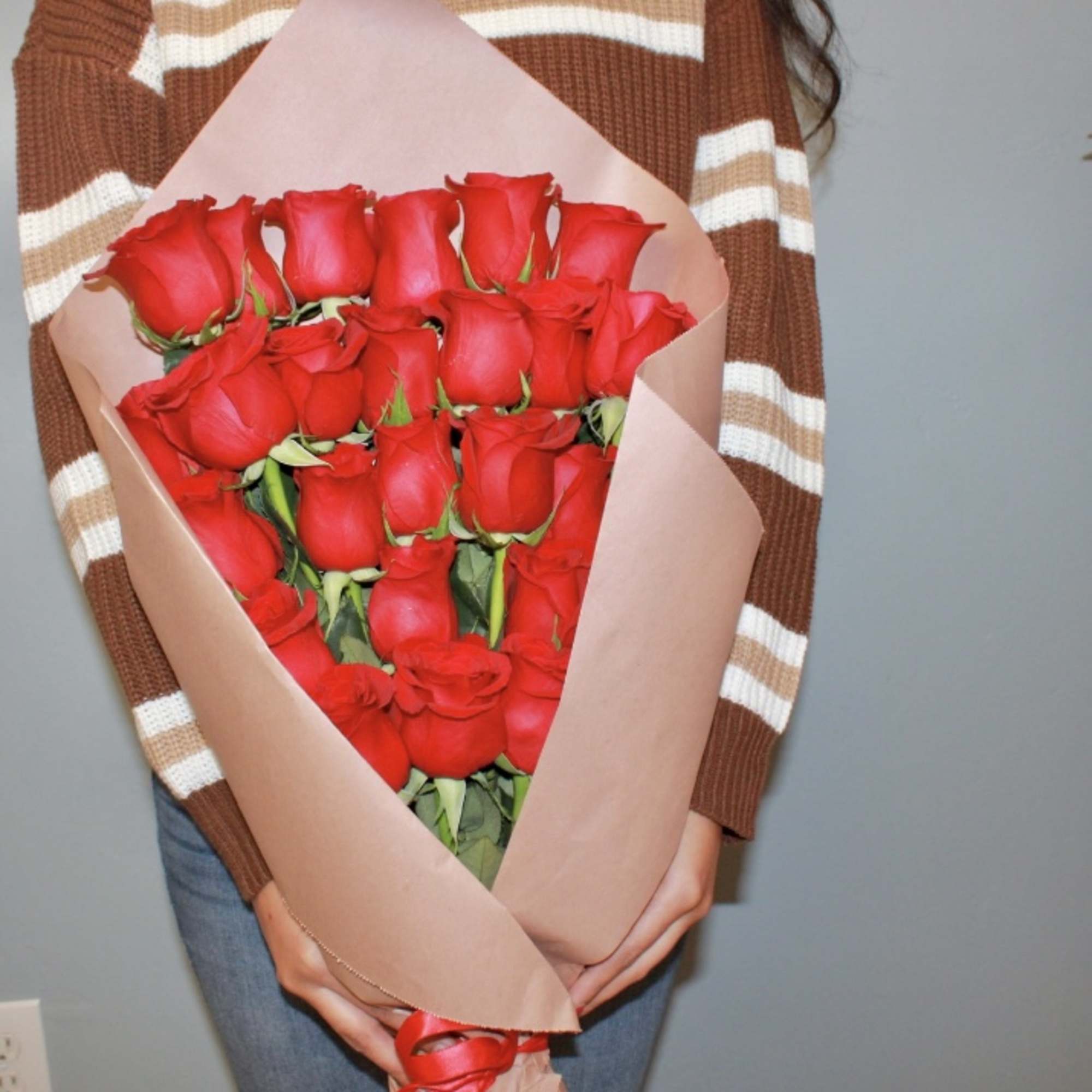 Bouquet of red roses wrapped in pink paper