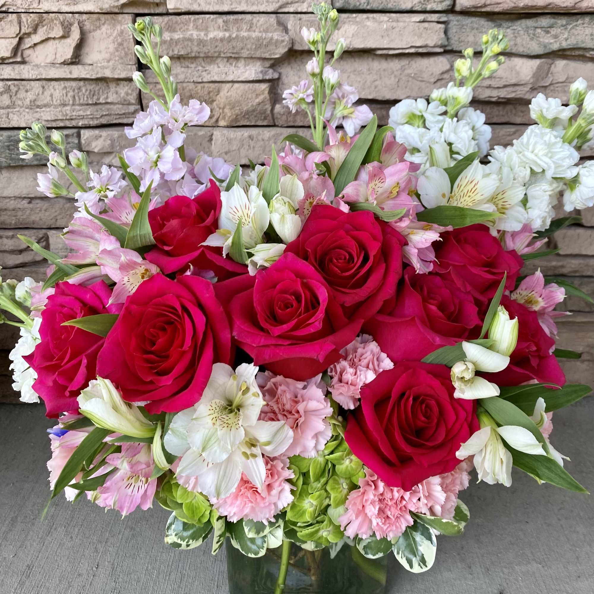 Pink roses and mixed pastel flowers in a glass vase