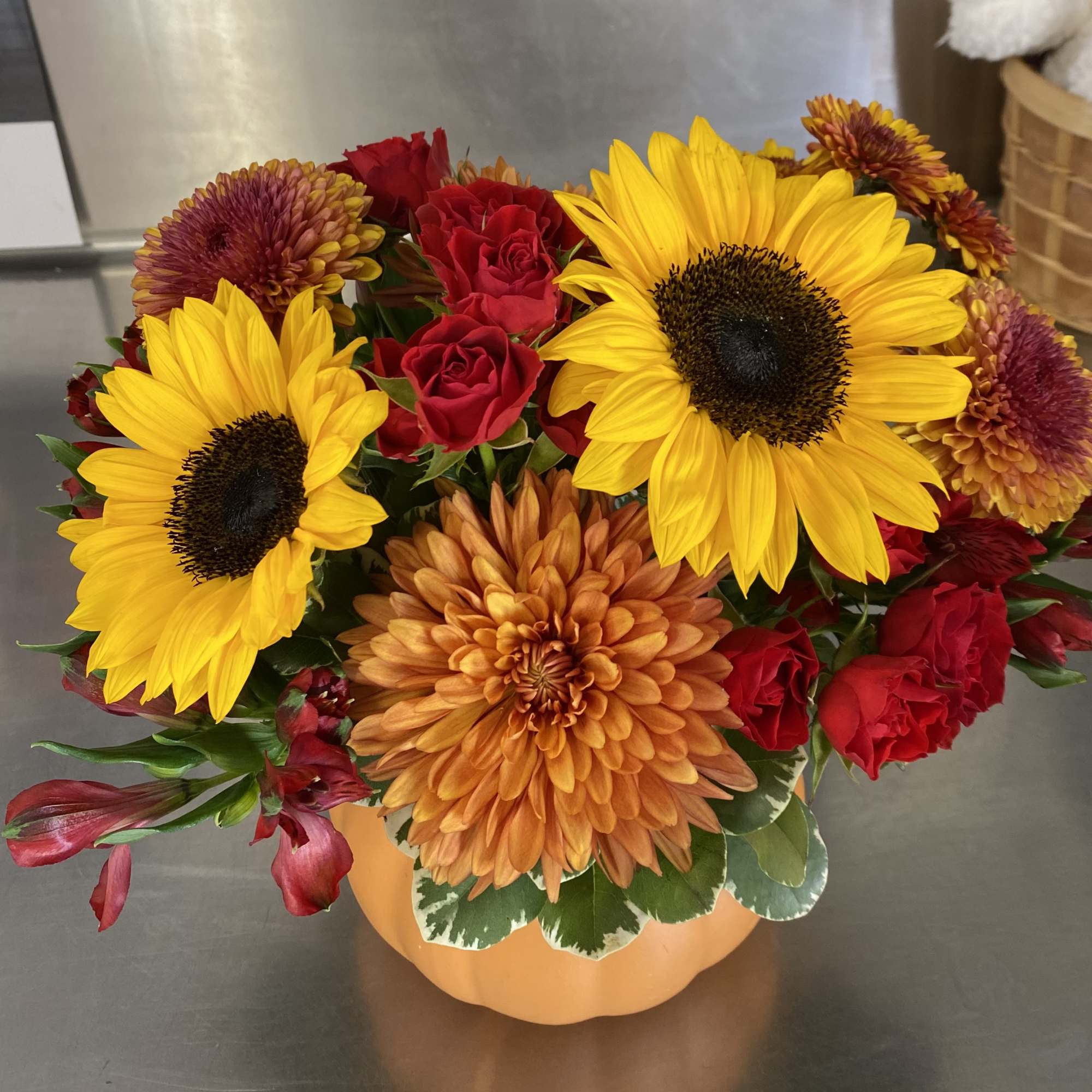 Combine the fall blooms with this wonderful pumpkin seasonal arrangement. Housed in