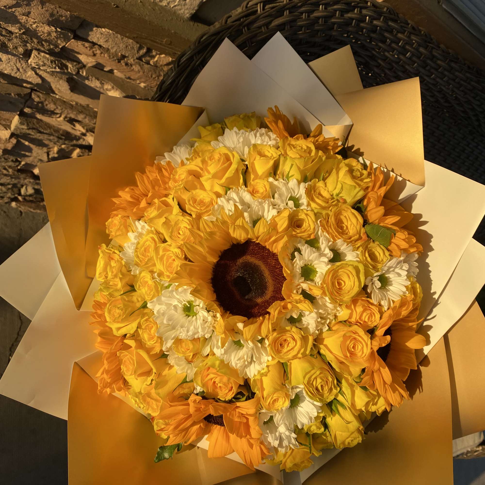 Yellow bouquet with roses, daisies, and a sunflower center
