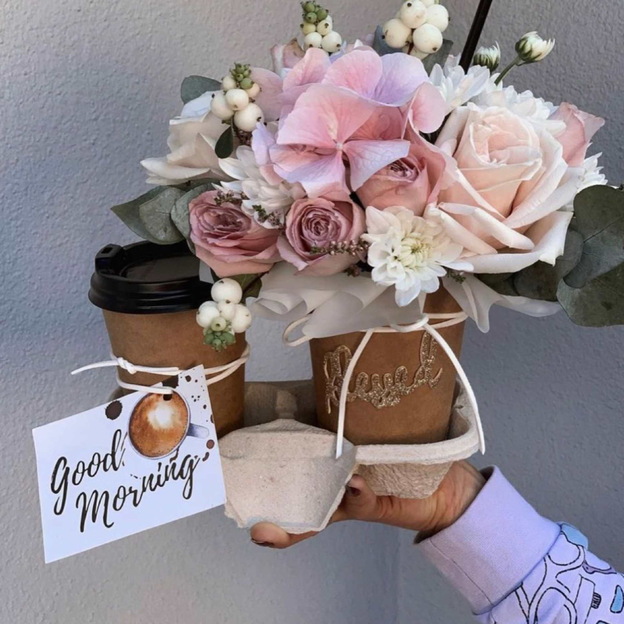 Two coffee cups with a pastel flower bouquet and a "good morning" tag