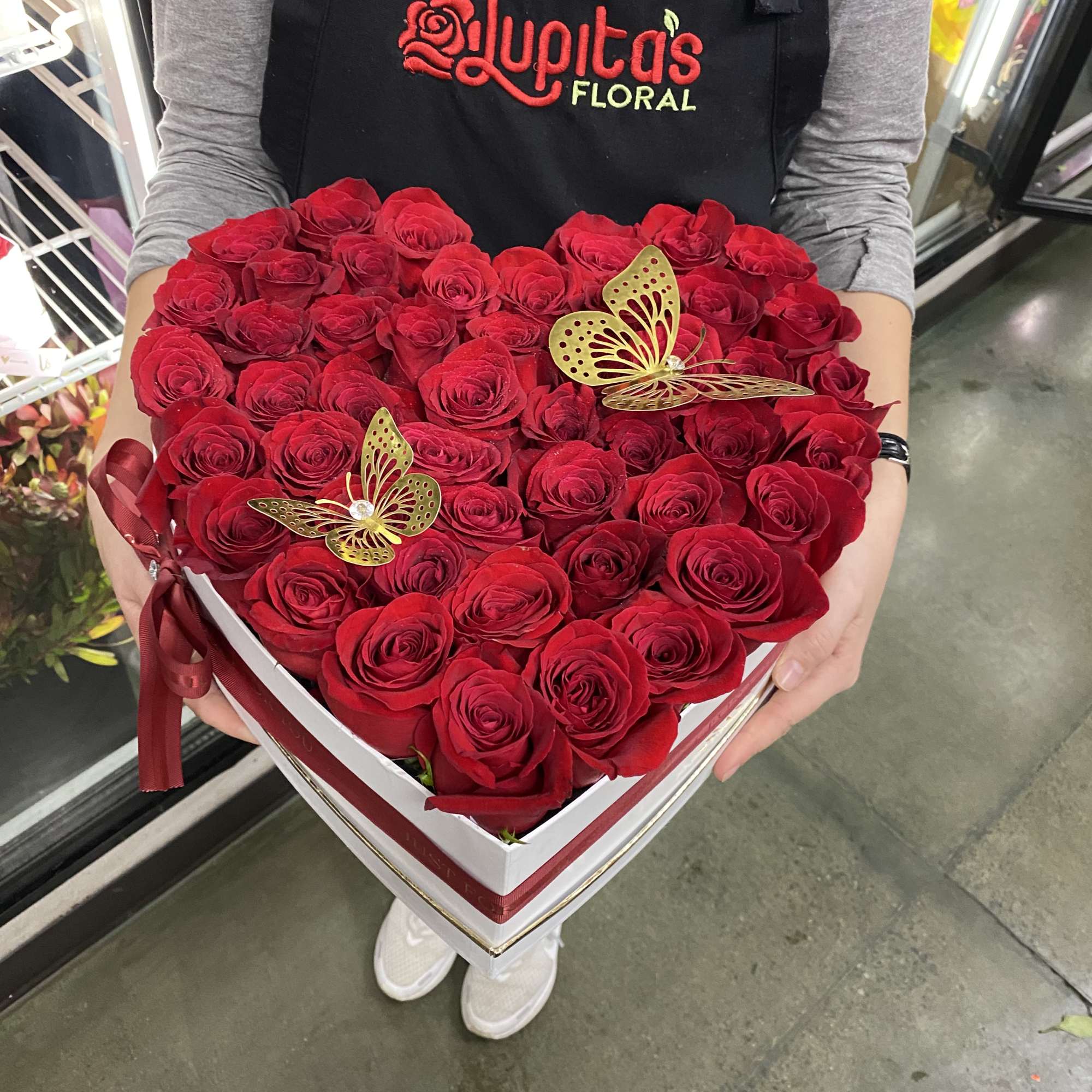 Heart-shaped box of red roses with gold butterfly picks
