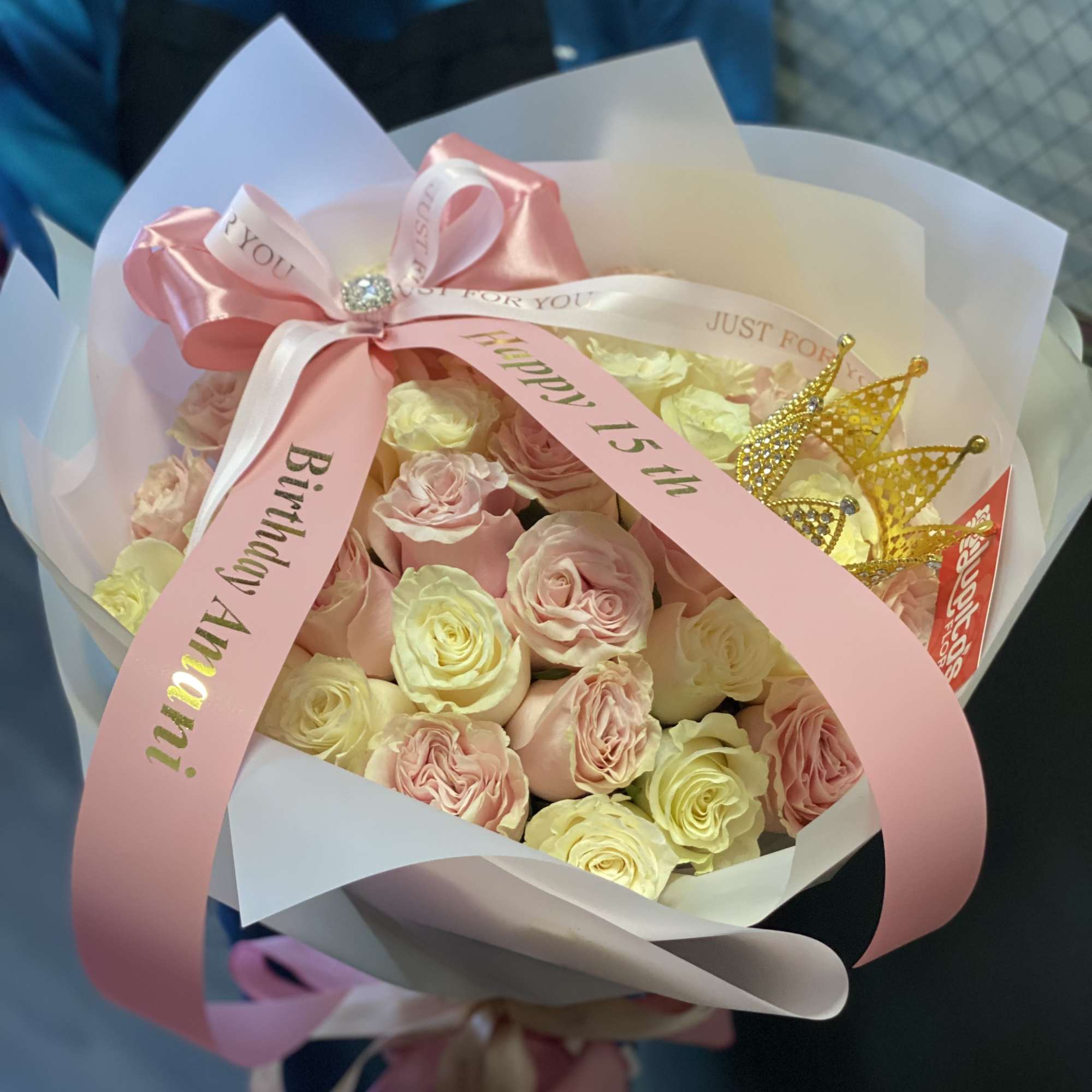 Bouquet of pale pink and cream roses wrapped with pink ribbon