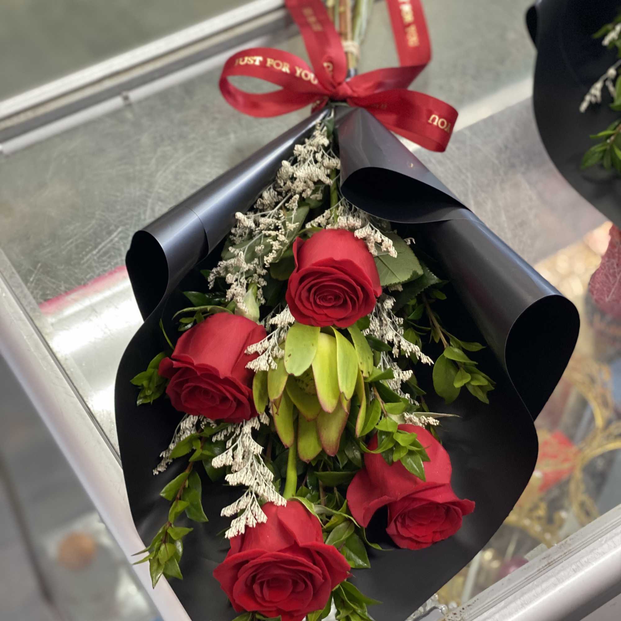Bouquet of red roses wrapped in black paper with a red ribbon, photo 2 of 3