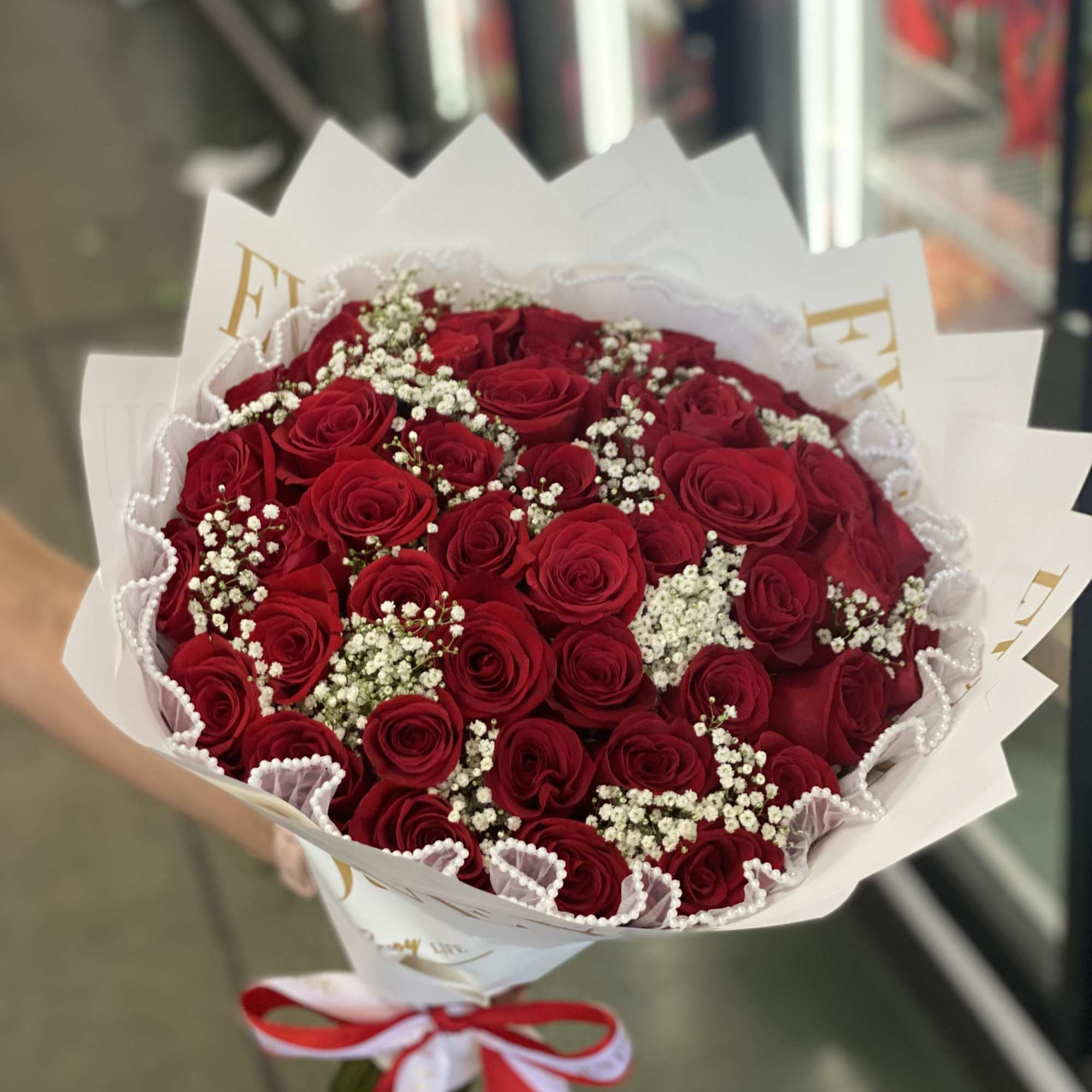Bouquet of red roses with white baby's breath in white wrapping, photo 2 of 2