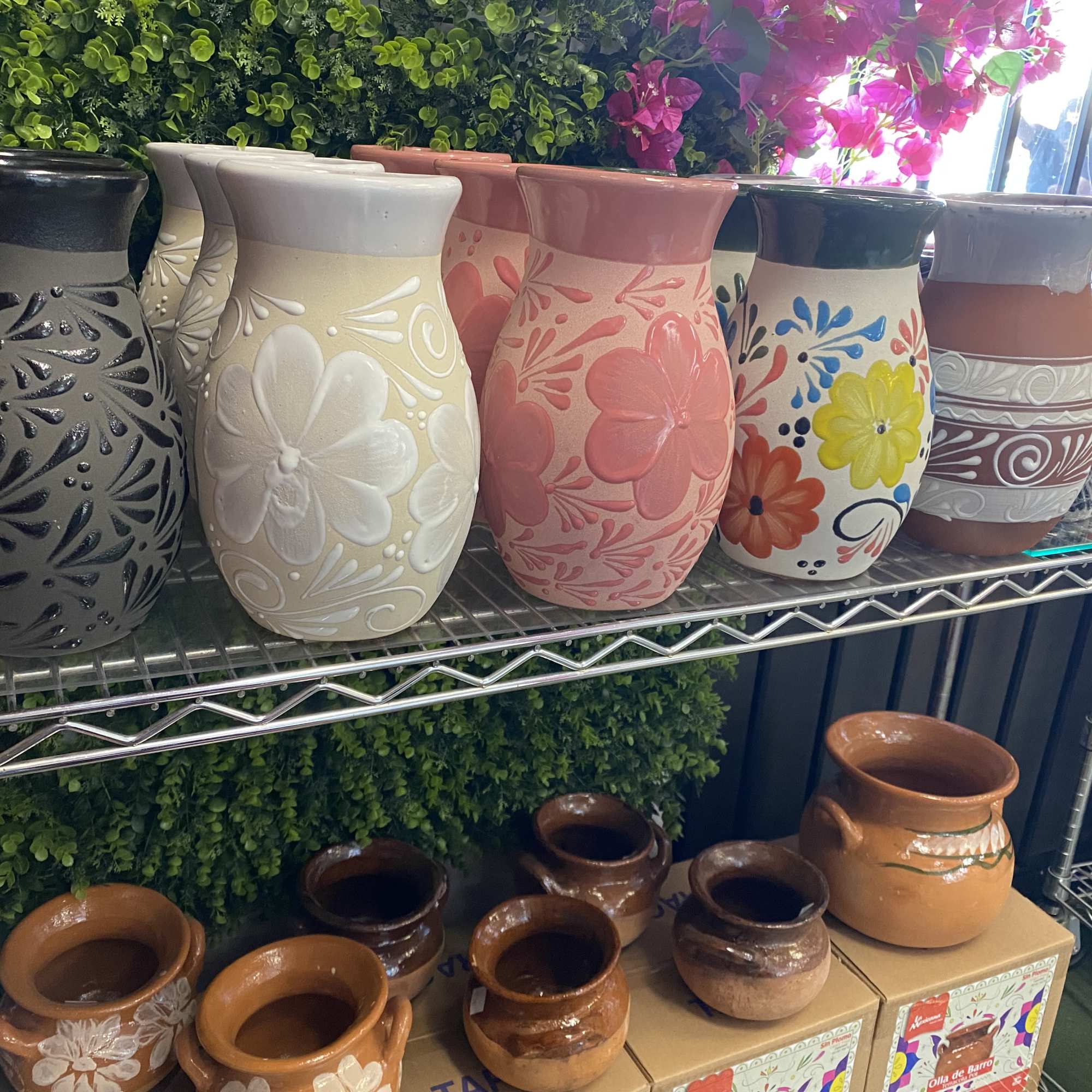 Decorative ceramic vases and pots displayed on metal shelves