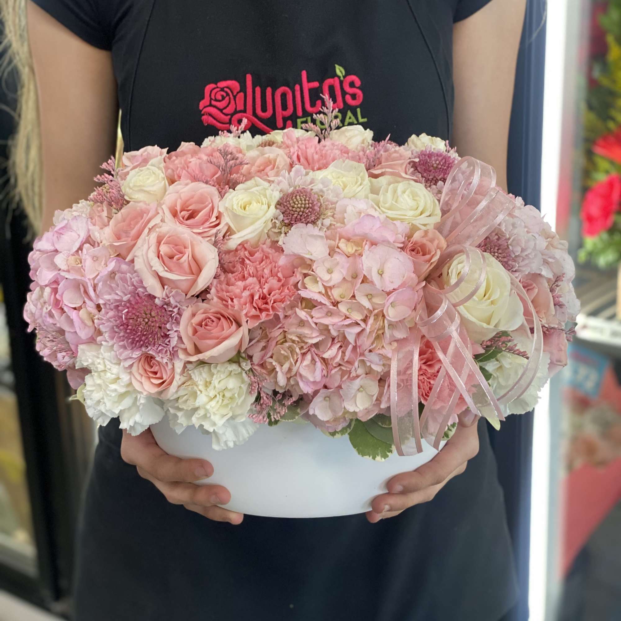 Pink and white rose arrangement in a white hat box with ribbon