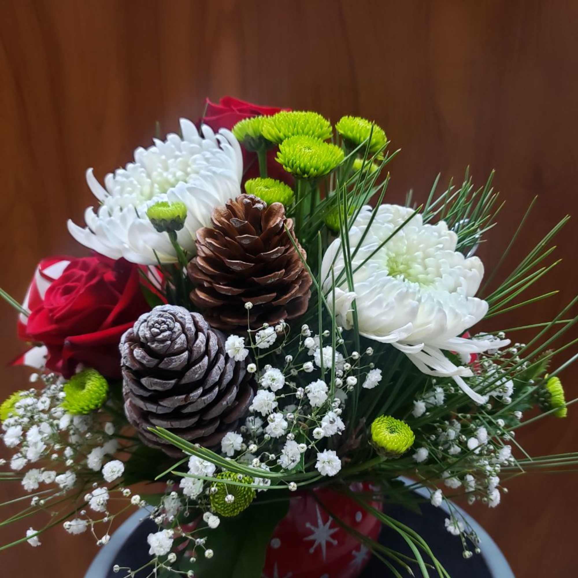 Bouquet of white chrysanthemums and red roses with pinecones