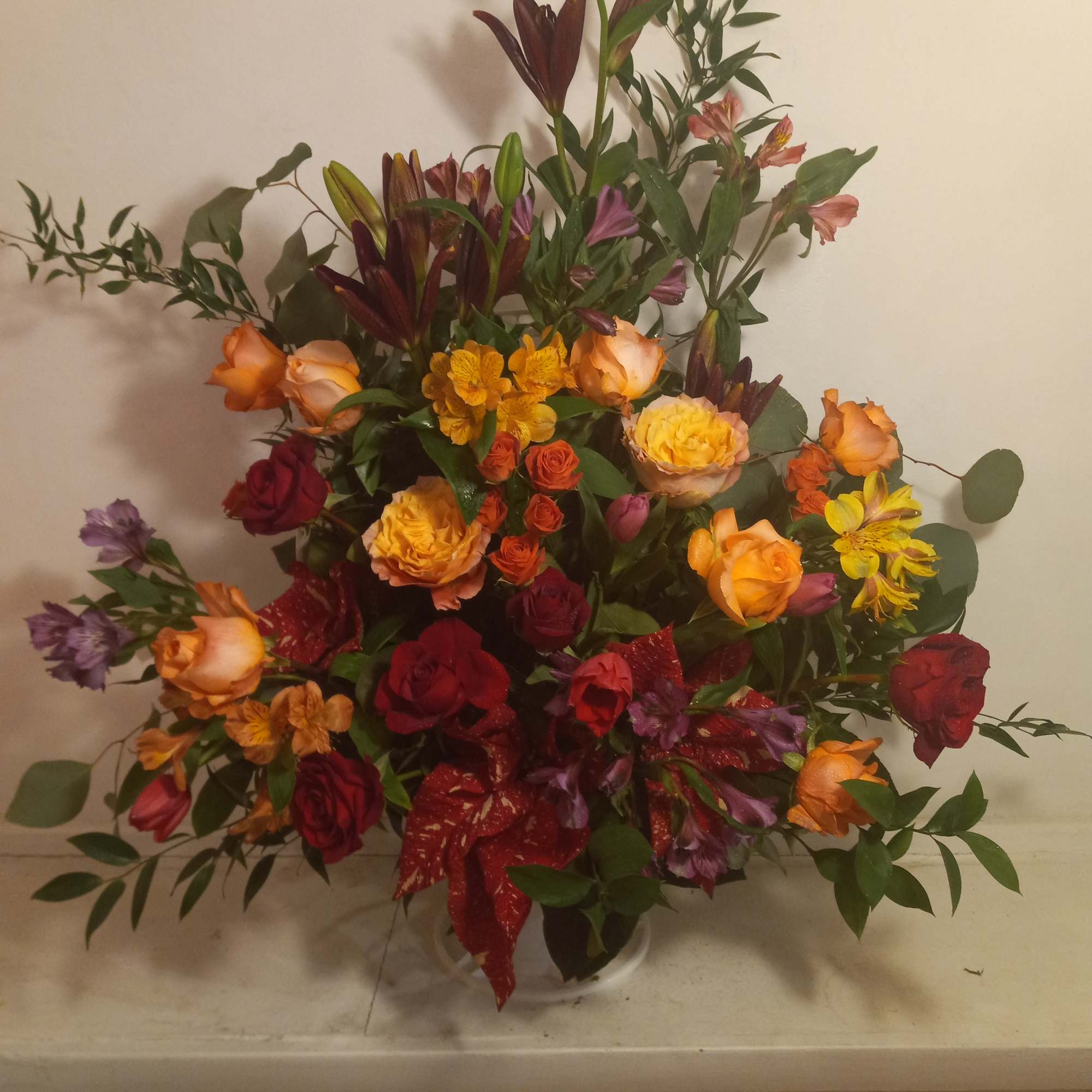 Mixed bouquet of roses, lilies, and alstroemeria in a vase