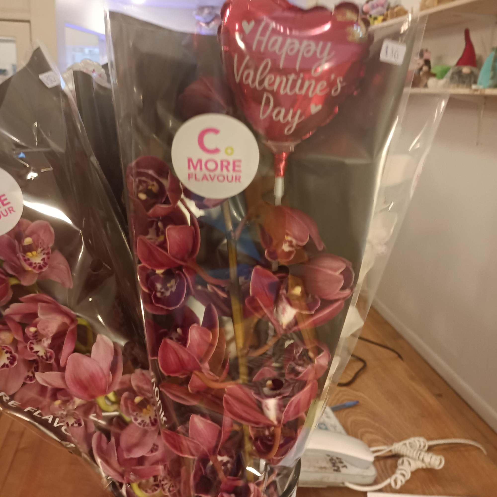 Wrapped orchid bouquet with a heart-shaped Valentine's Day balloon