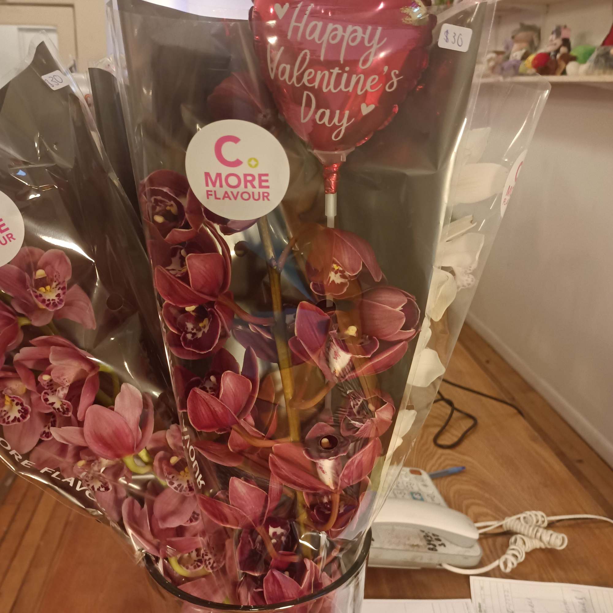 Pink orchid bouquet in clear wrap with a Valentine’s Day balloon