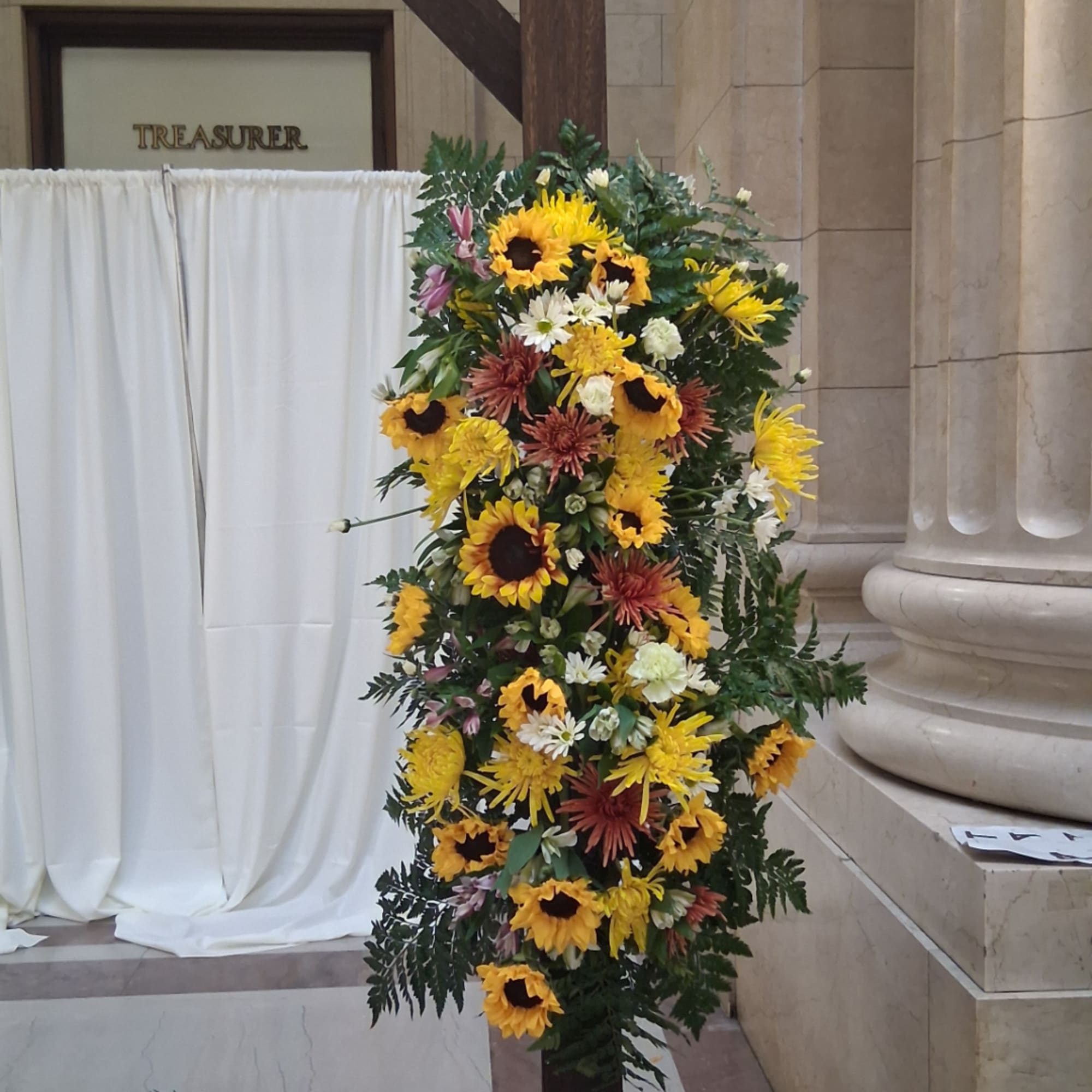 Tall floral standing arrangement with sunflowers and mixed blooms