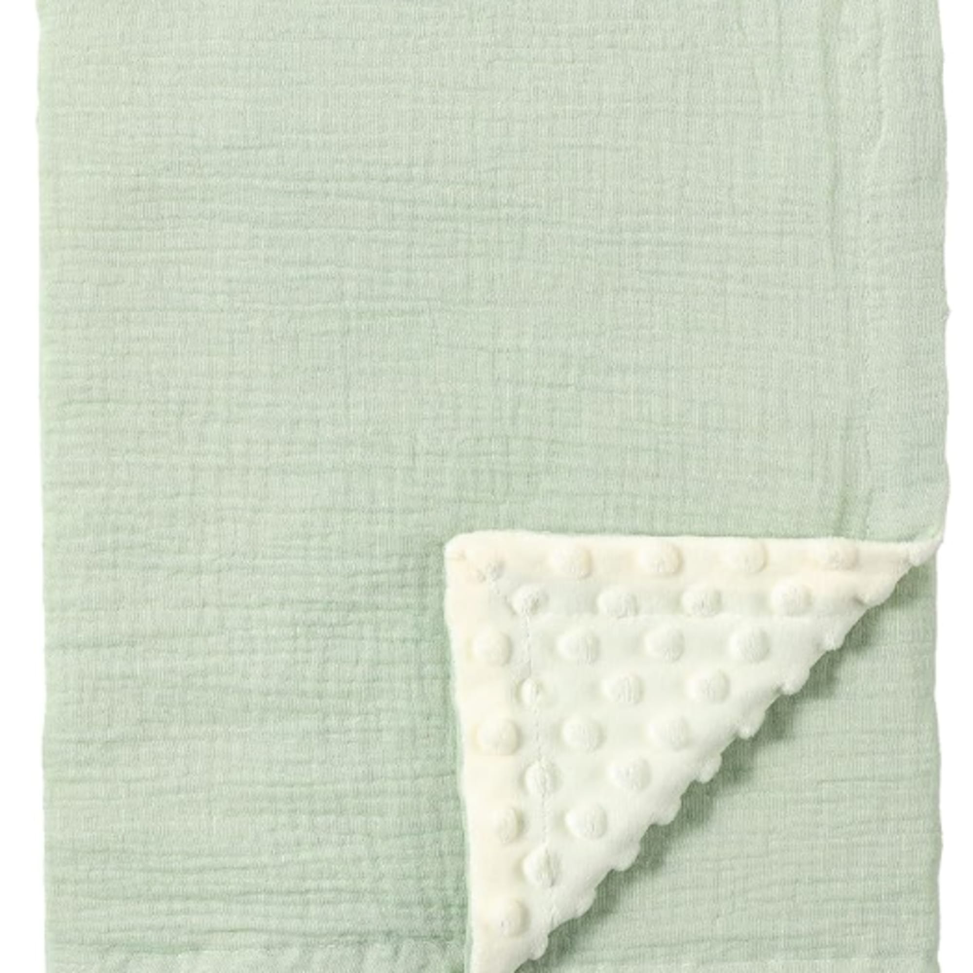 Mint green baby blanket with a white textured corner