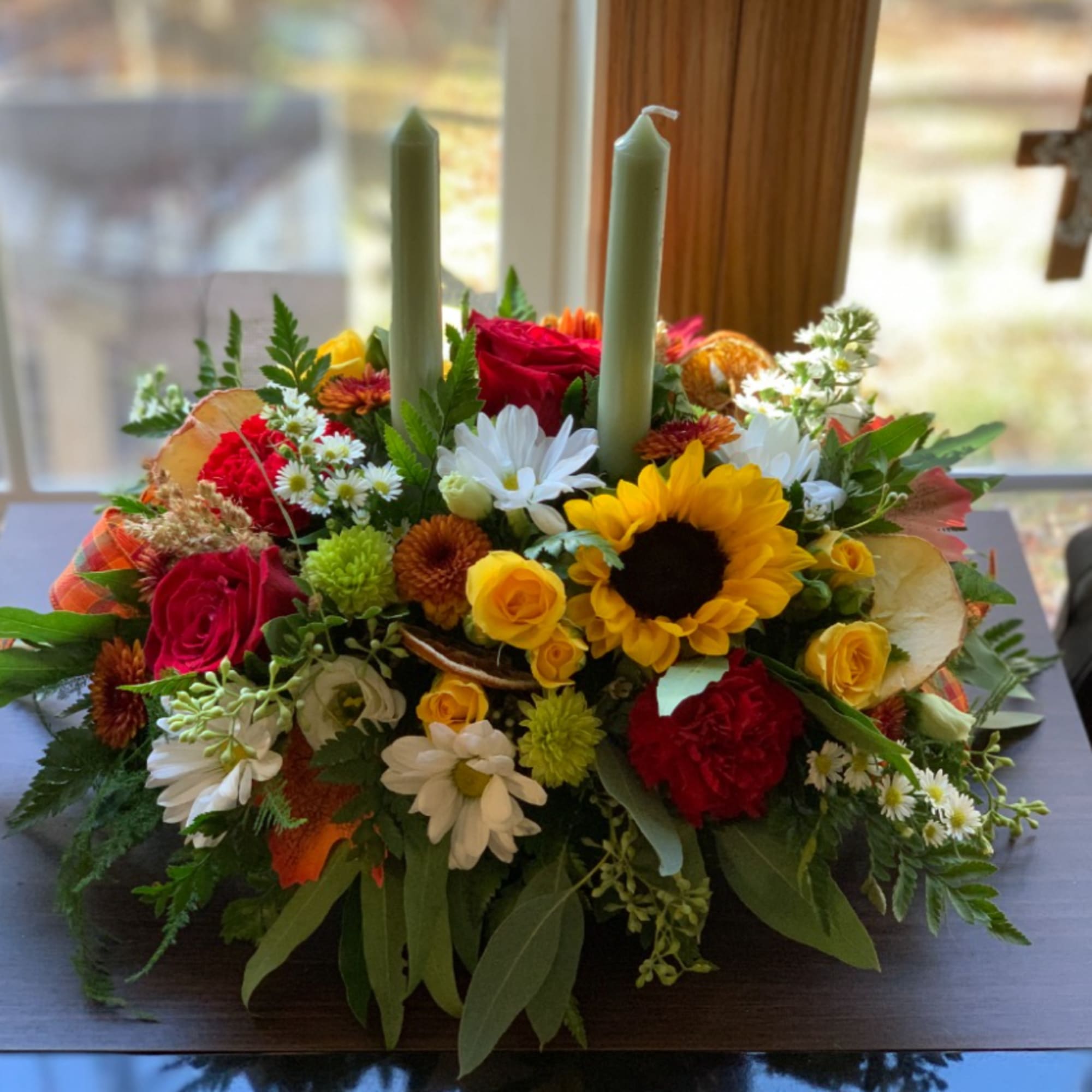 Colorful floral centerpiece with two taper candles in a low arrangement