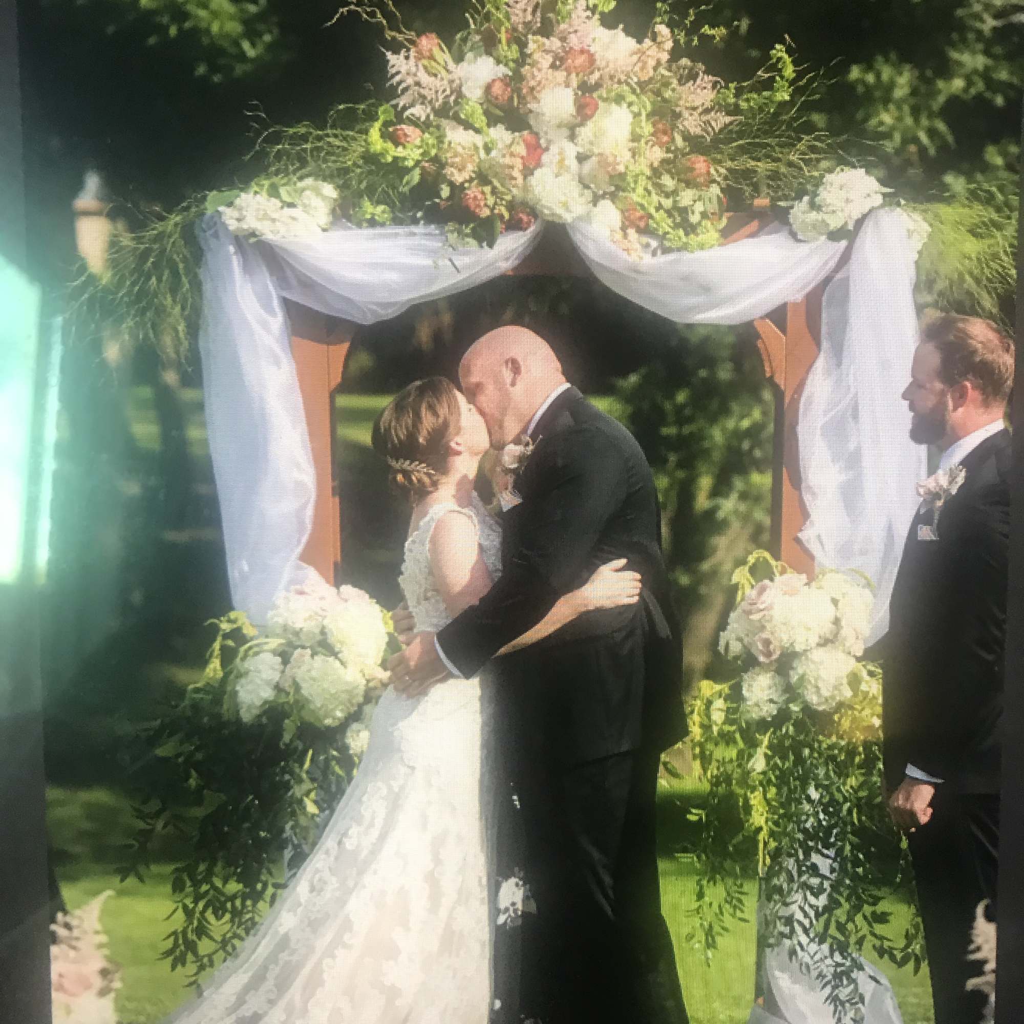 Wedding arch decorated with white draping and pastel flowers